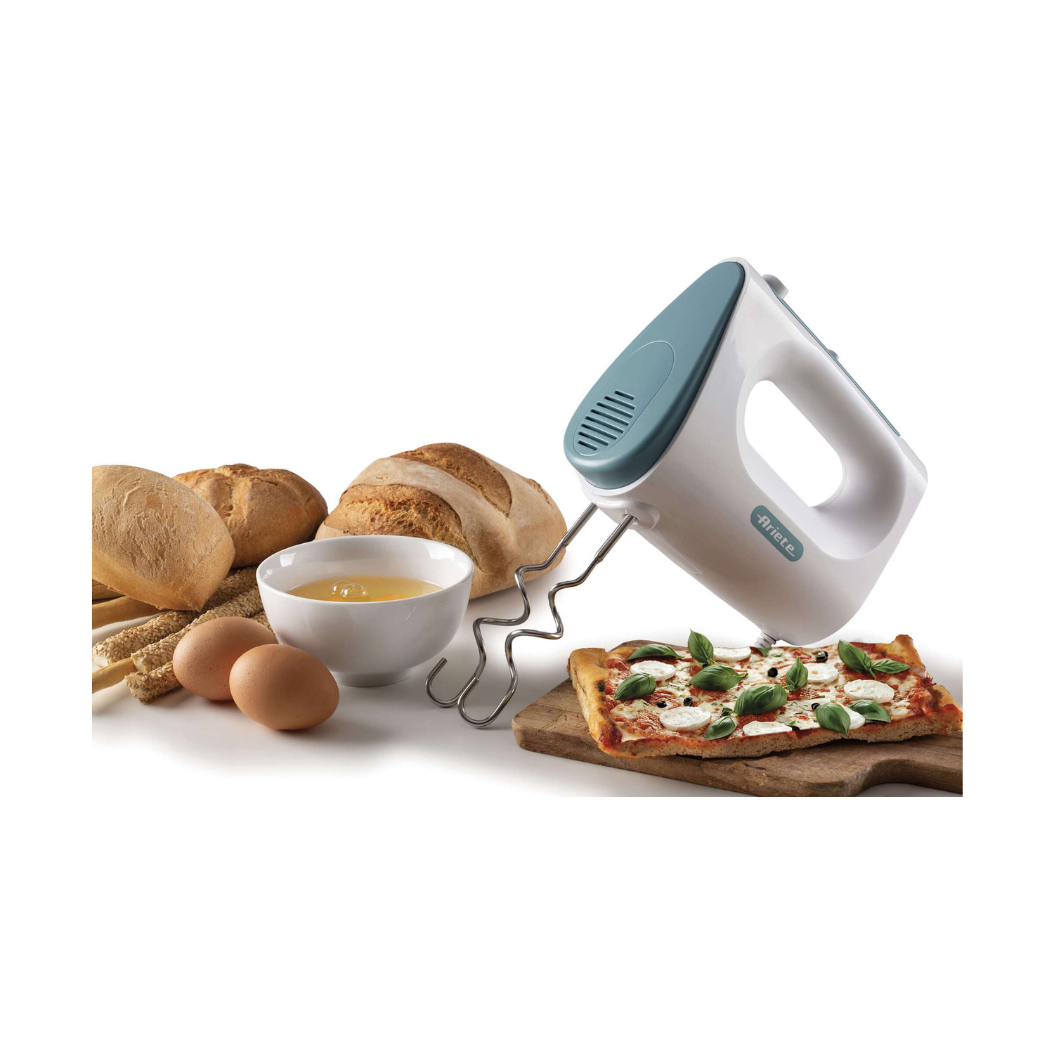 Un mixer a mano bianco e verde tesa, pane, uova, una ciotola con tuorlo e pizza.