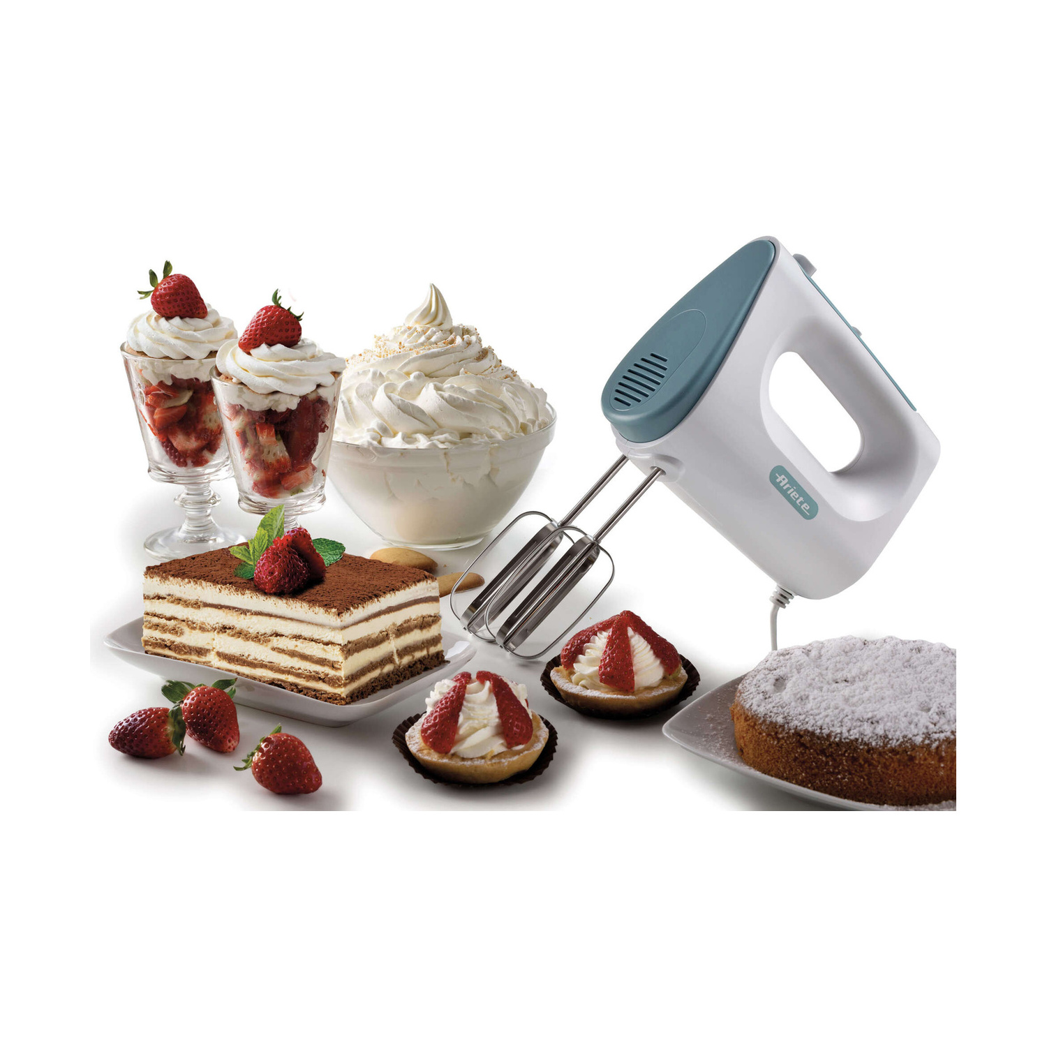 Un frullatore a mano bianco e verde acqua circondato da dolci, torte e fragole fresche.