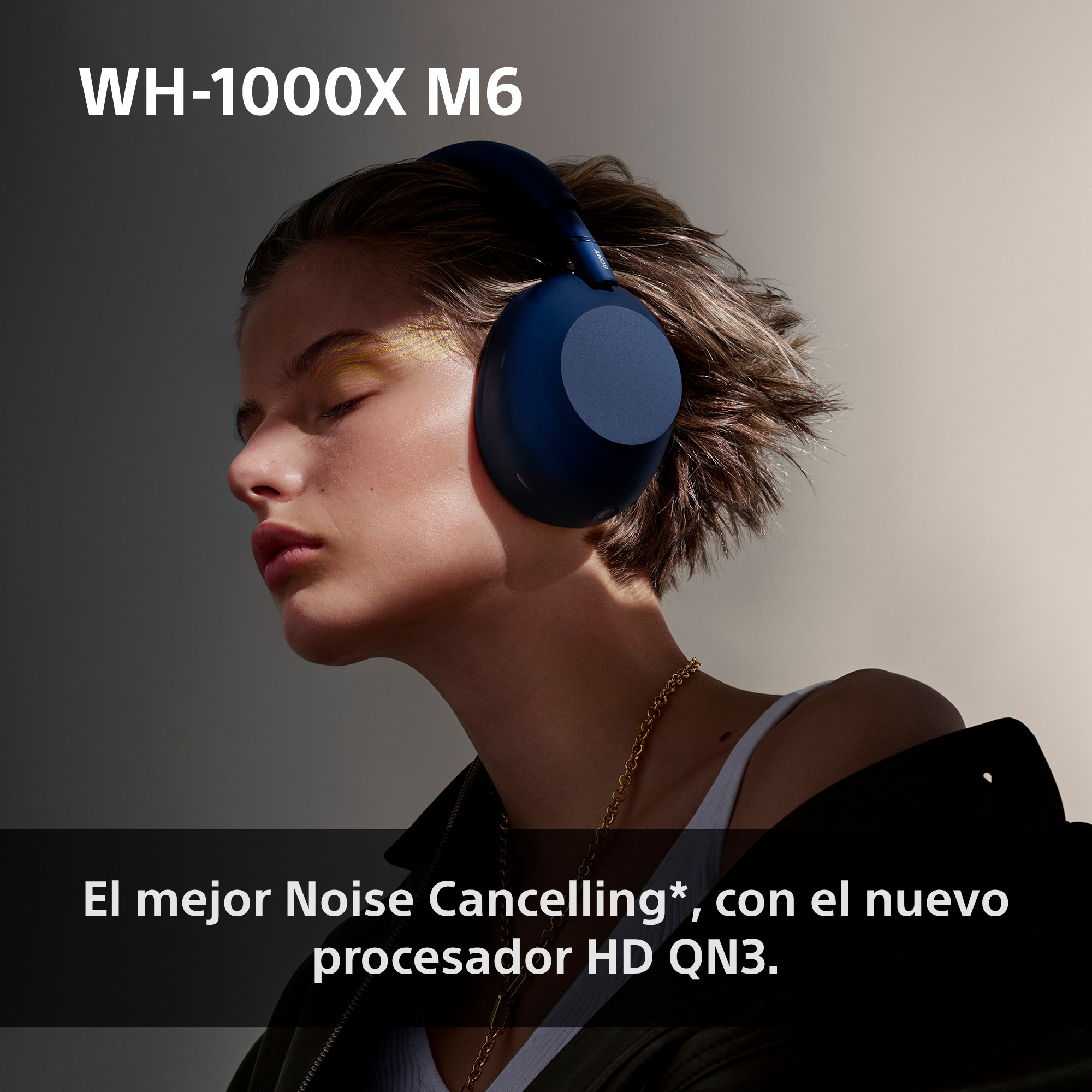 Una persona con los ojos cerrados lleva auriculares supraurales azules sobre fondo neutro.