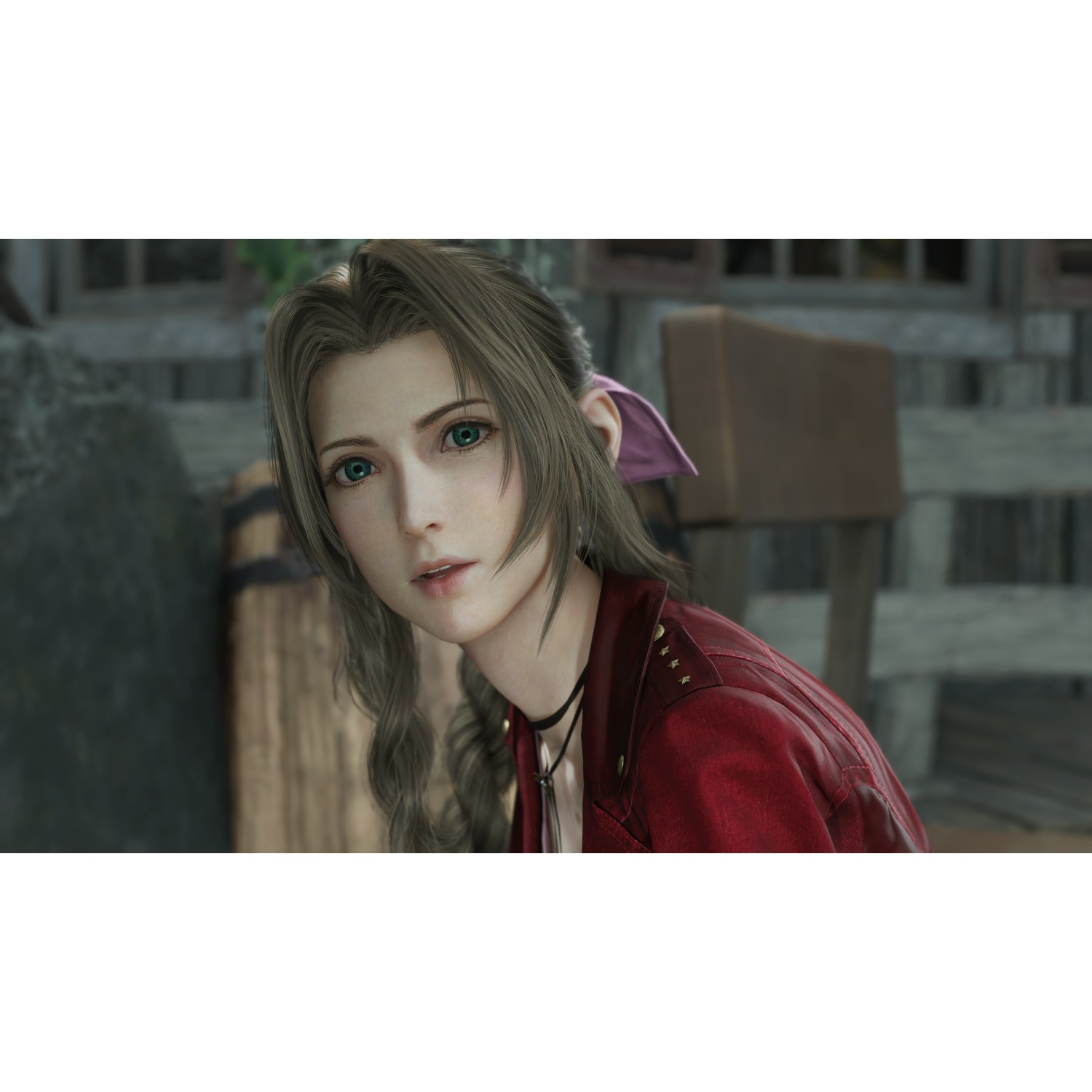Une femme aux longs cheveux bruns et aux yeux verts vêtue d'une veste rouge devant un décor rustique.