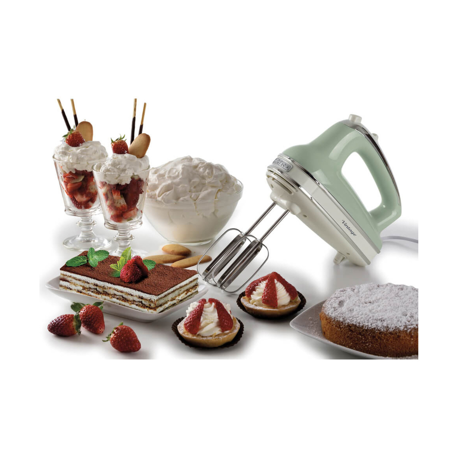 Uno sbattitore a mano verde pastello è circondato da dolci, tra cui tiramisù, coppe di fragole, crostatine e una torta.