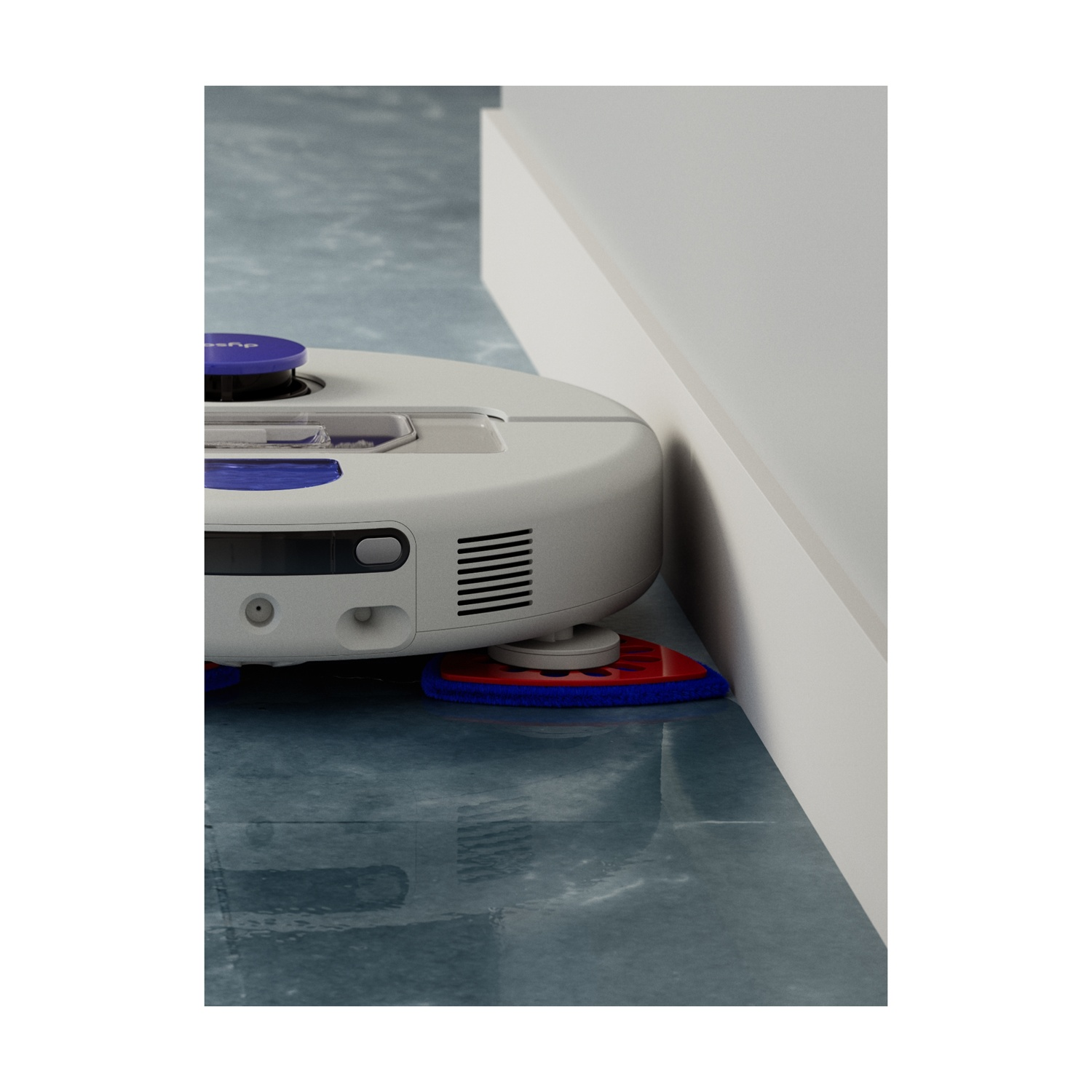 Un robot aspirapolvere bianco con dettagli blu pulisce lungo un battiscopa bianco su un pavimento blu.