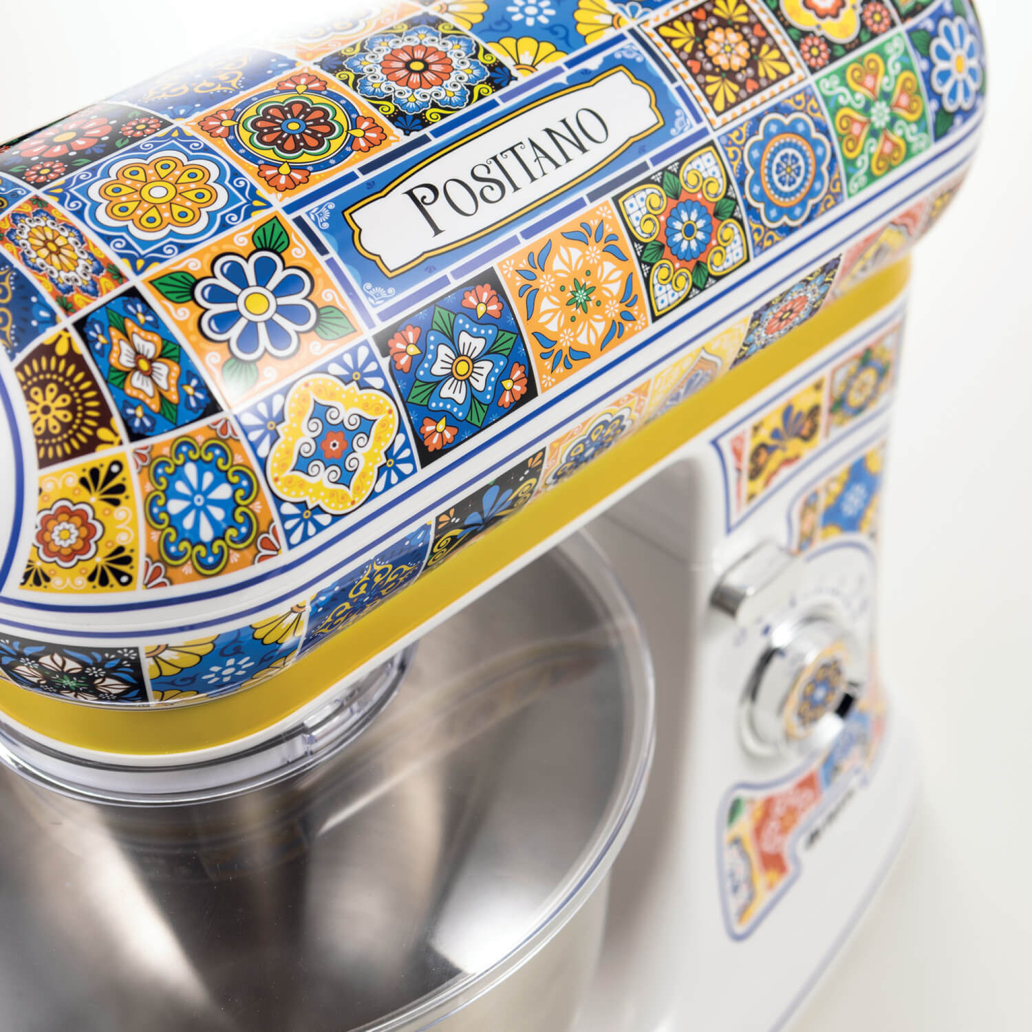 Un'impastatrice bianca decorata con colorate piastrelle in stile maiolica di Positano, su sfondo bianco.