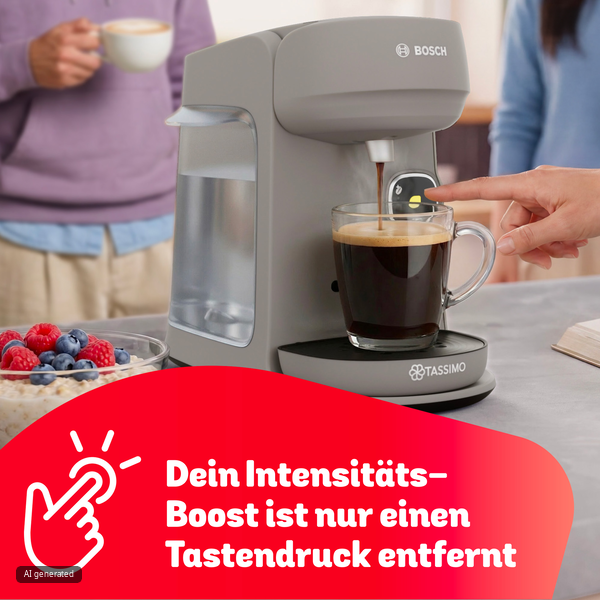Eine graue Bosch-Tassimo-Kaffeemaschine brüht Kaffee in eine Tasse, während eine Hand die Taste drückt.