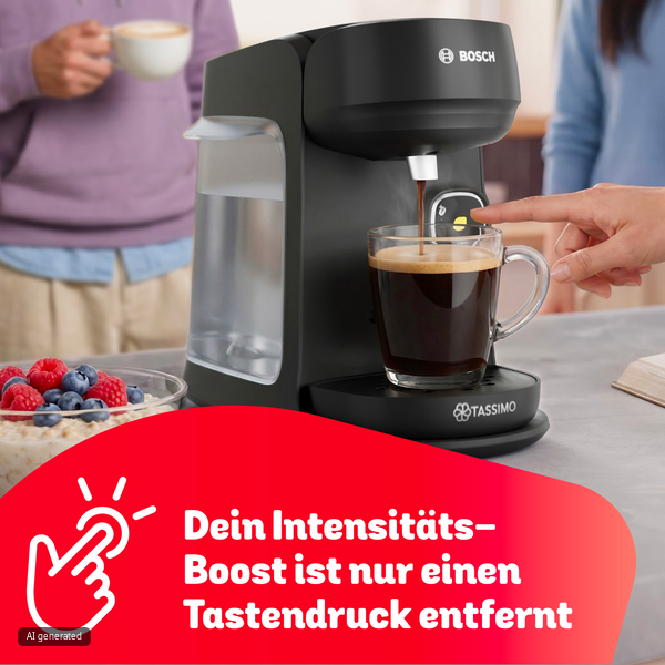Eine schwarze Tassimo Kaffeemaschine brüht Kaffee in eine Glastasse, während eine Hand einen Knopf drückt.