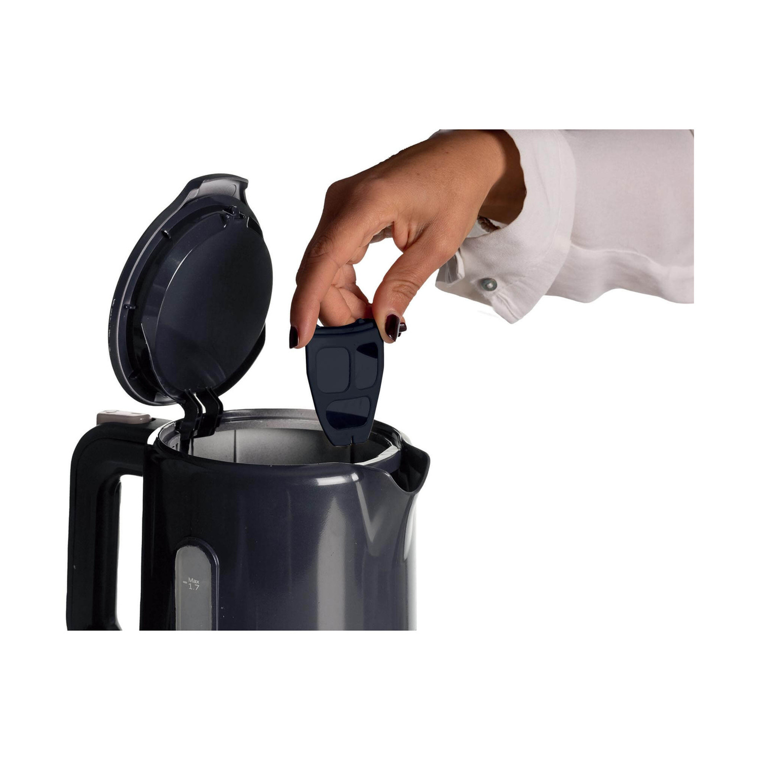 Una mano inserisce un filtro in un bollitore elettrico grigio aperto.