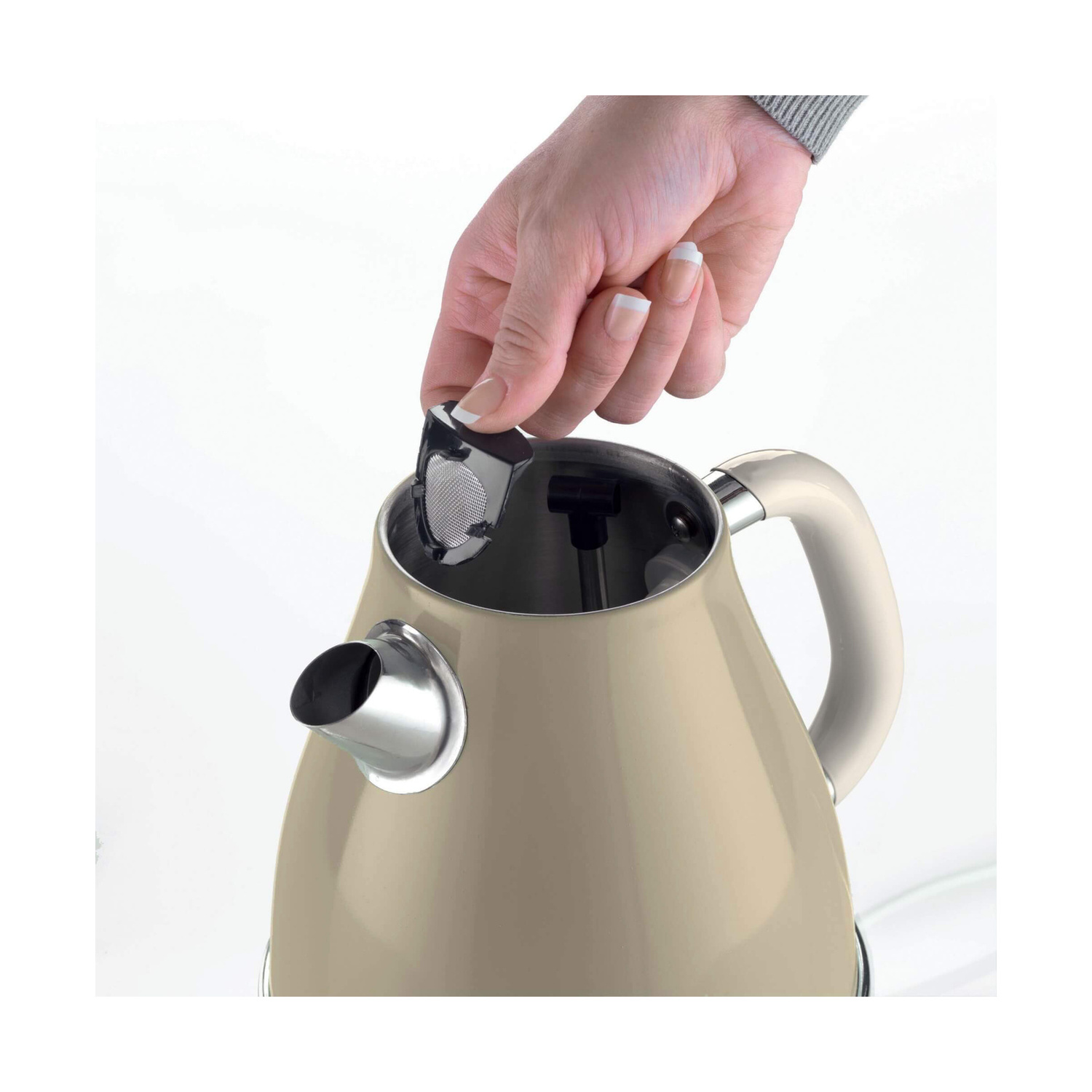 Una mano inserisce un filtro in un bollitore elettrico beige.