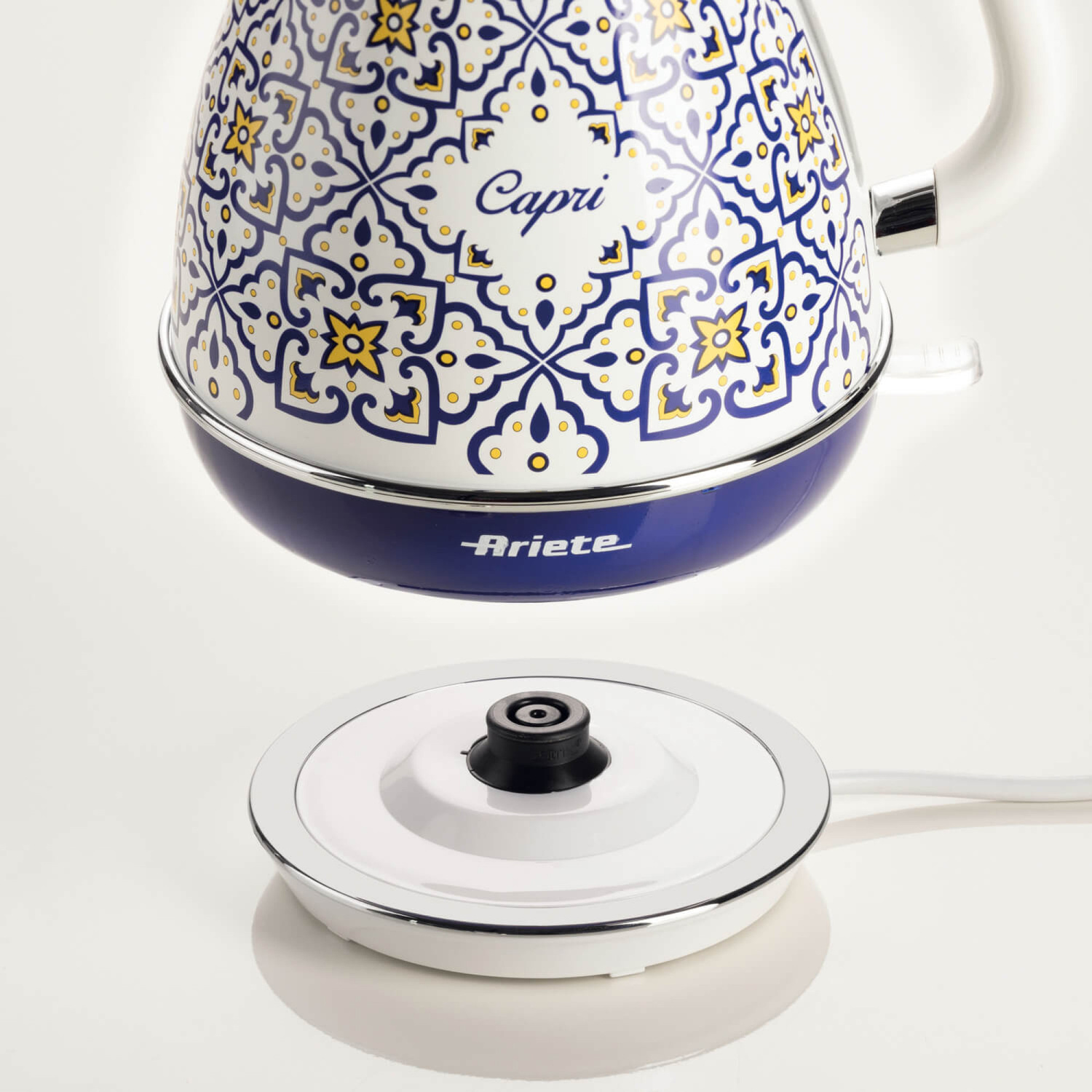 Bollitore elettrico Ariete Capri blu e bianco con motivo mediterraneo sopra la base bianca.