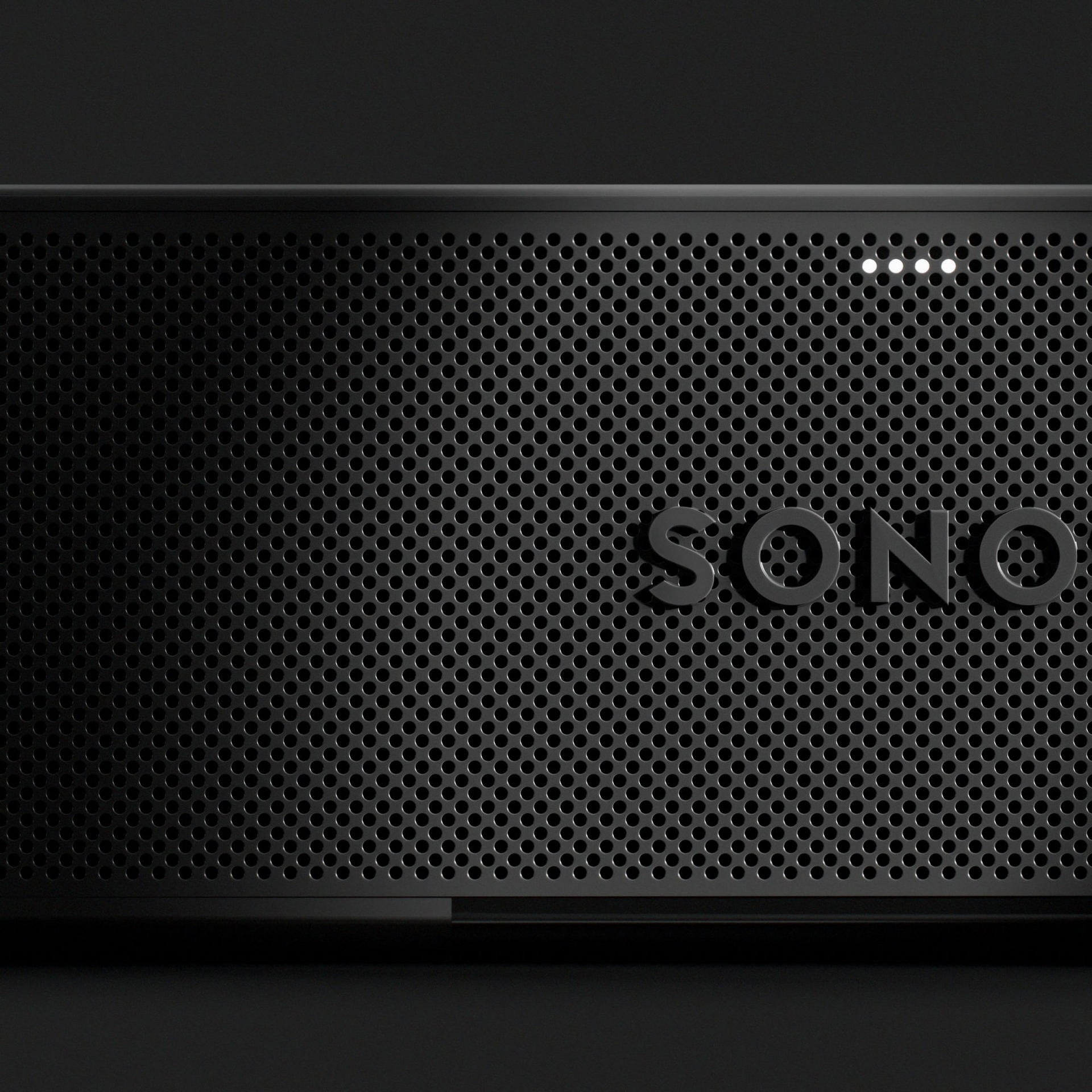 Fekete Sonos hangszóró perforált fémráccsal és négy kis fehér LED lámpával a tetején.