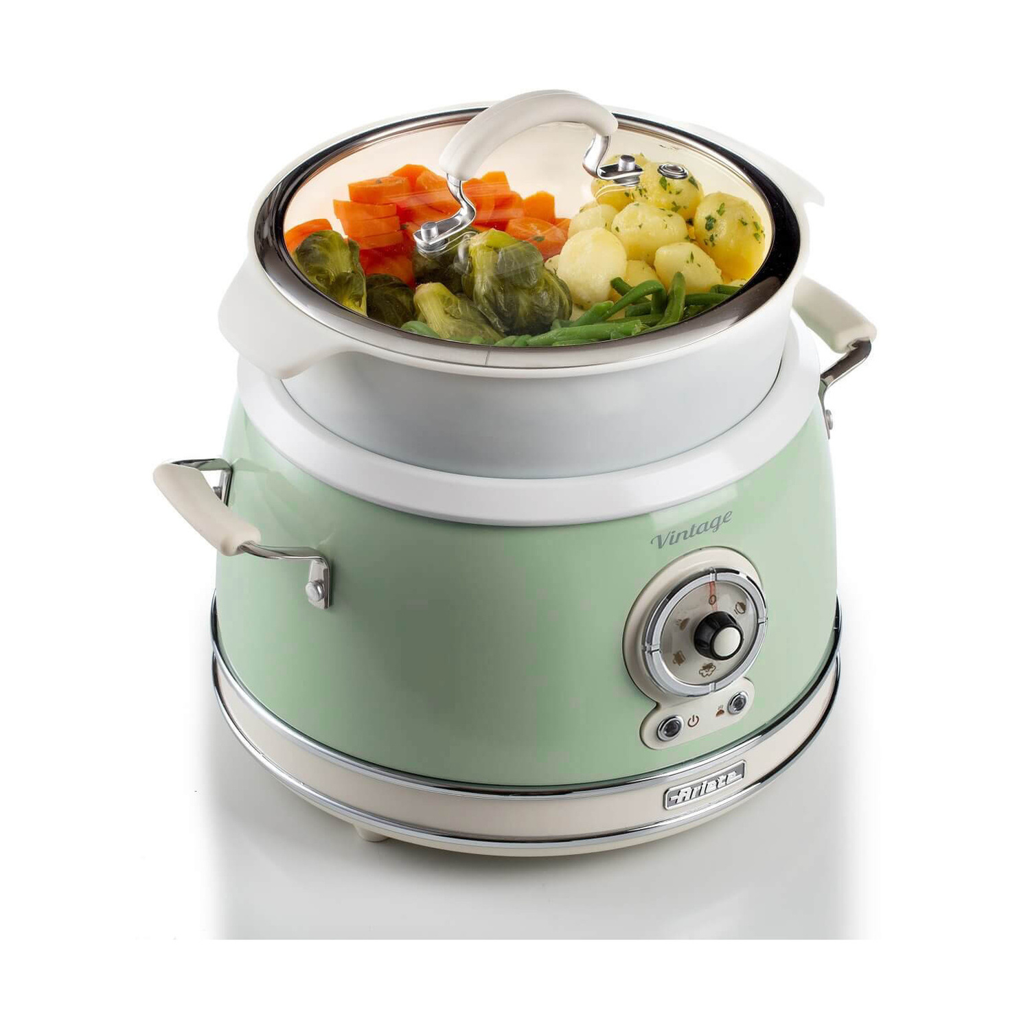 Una vaporiera in stile vintage verde chiaro e bianca piena di carote, patate e cavolini di Bruxelles.