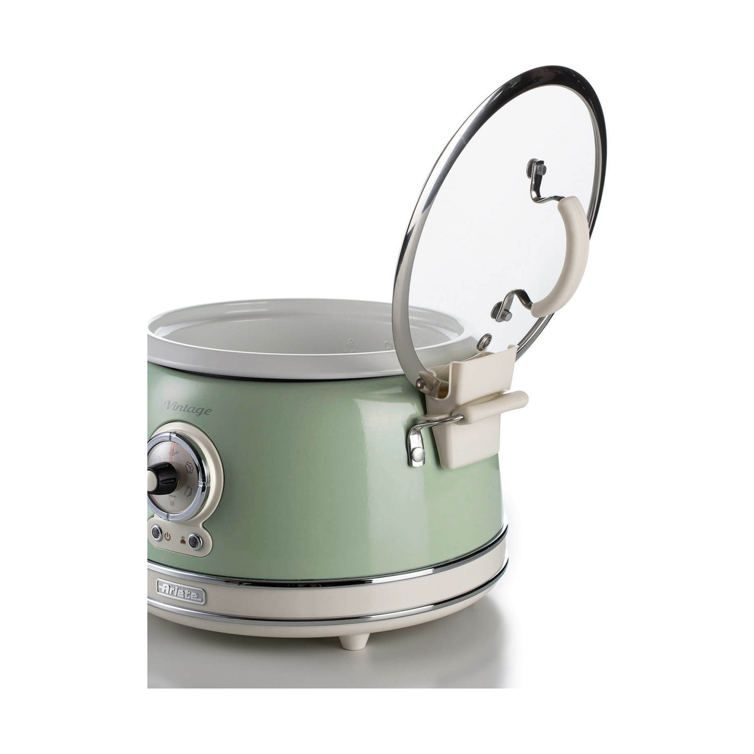 Pentola a cottura lenta vintage verde chiaro e crema con coperchio in vetro aperto su sfondo bianco.