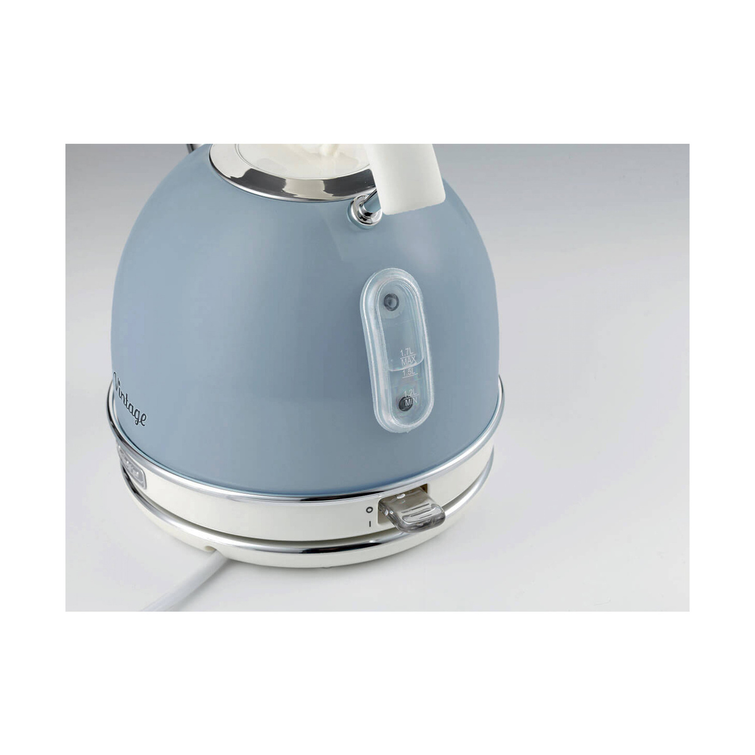 Bollitore elettrico vintage blu pastello con base bianca e indicatore del livello dell'acqua su sfondo bianco.