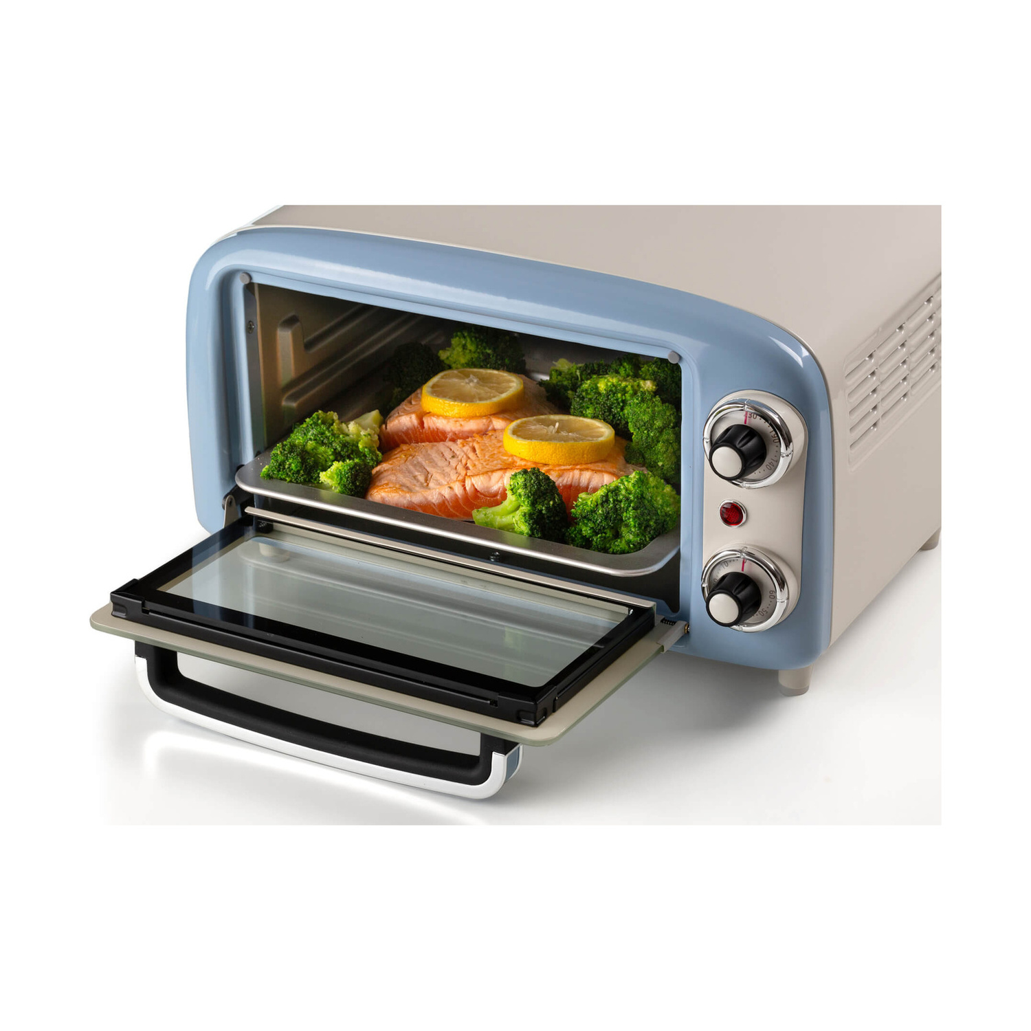 Un mini forno blu con la porta aperta mostra filetti di salmone, broccoli e fette di limone su una teglia.