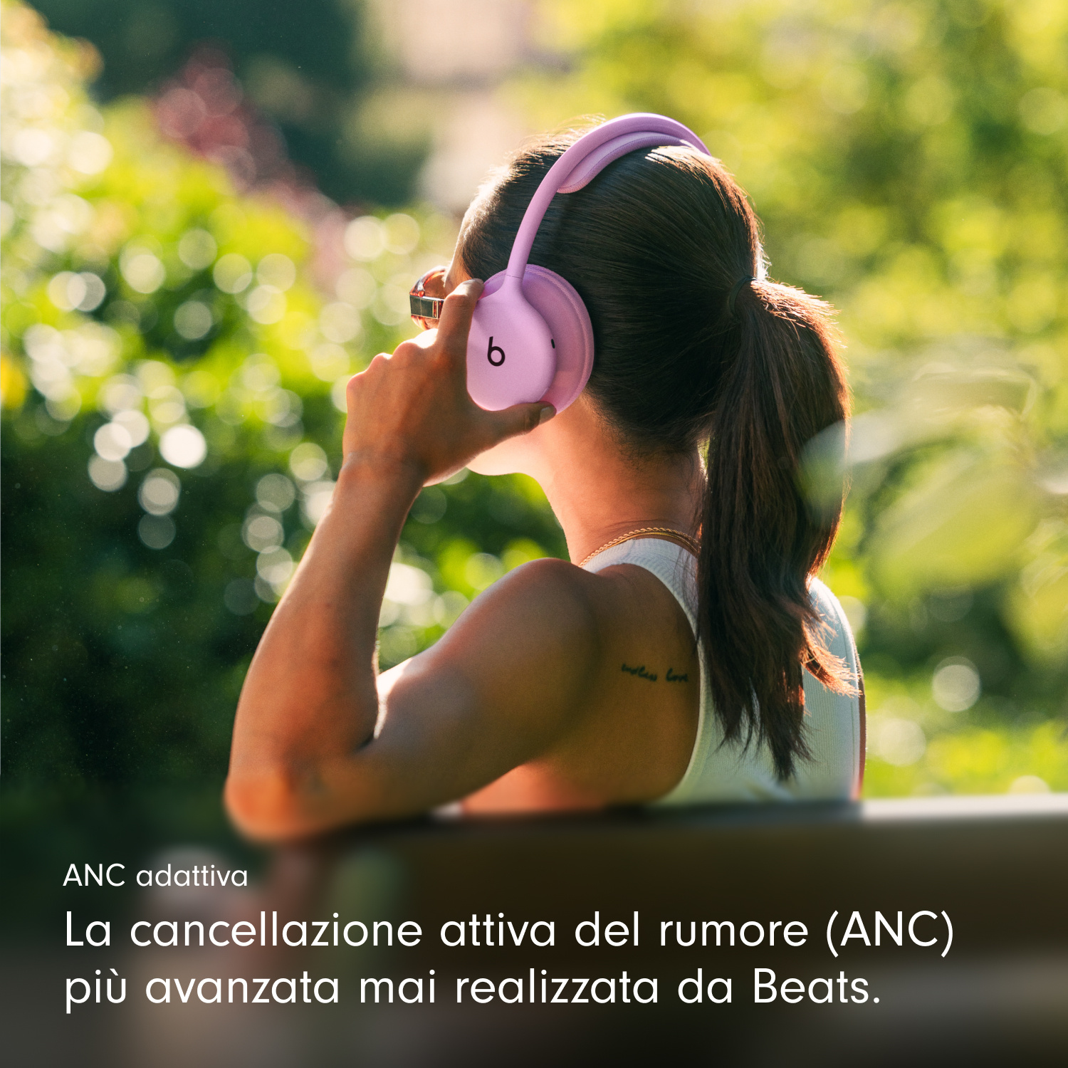 Una donna all'aperto con cuffie rosa, sfondo verde e testo sovrapposto.