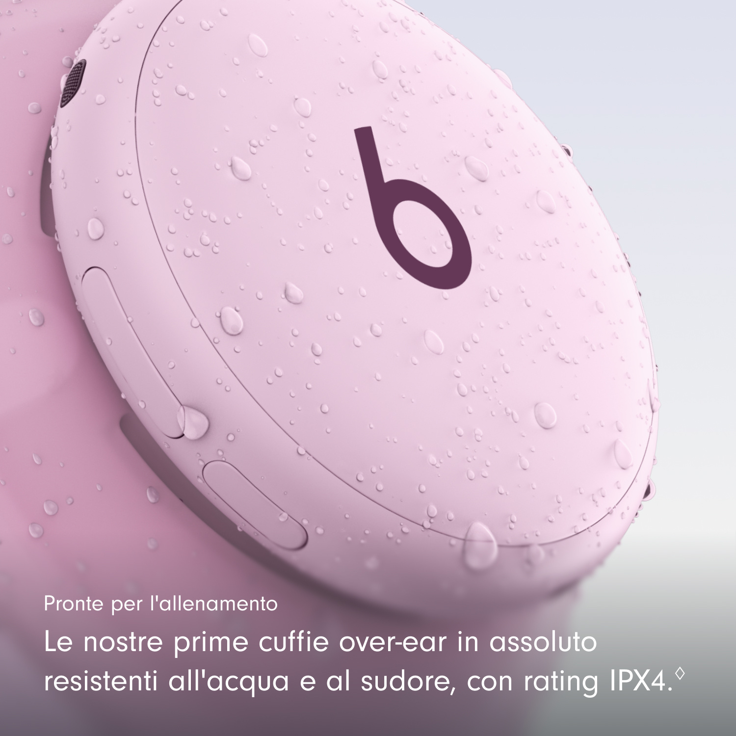 Gocce d'acqua su un padiglione di cuffie over-ear rosa Beats con logo.