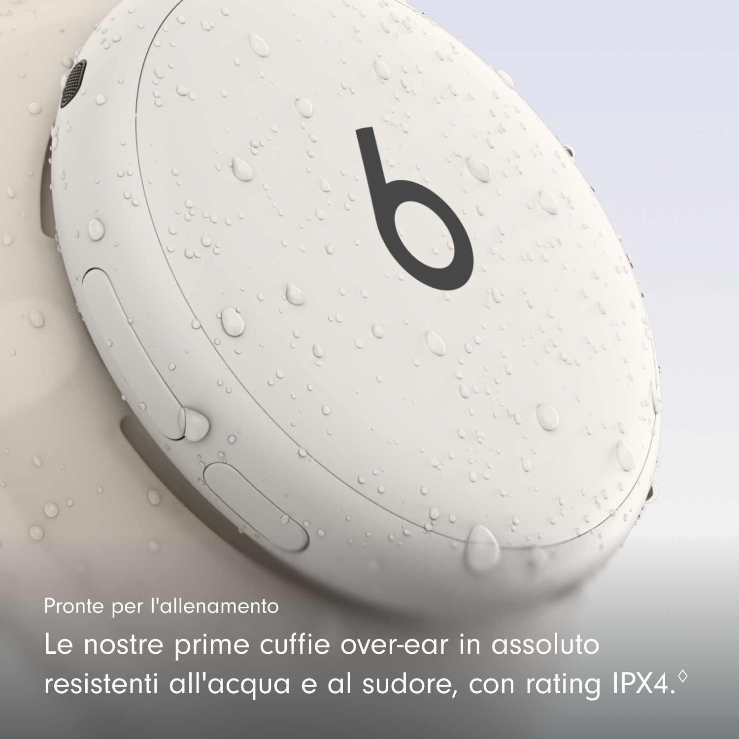 Gocce d'acqua su un padiglione auricolare wireless beige con logo Beats nero.