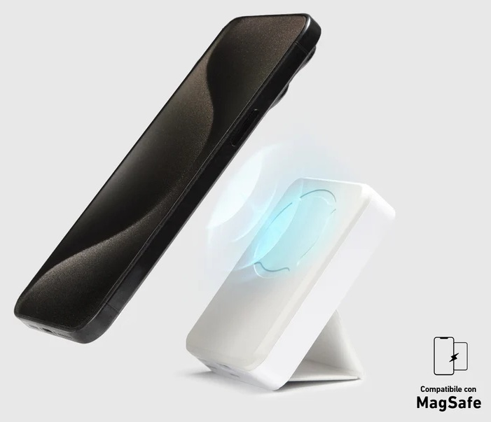 Czarny smartfon unosi się nad białym stojakiem ładującym MagSafe na jasnoszarym tle.