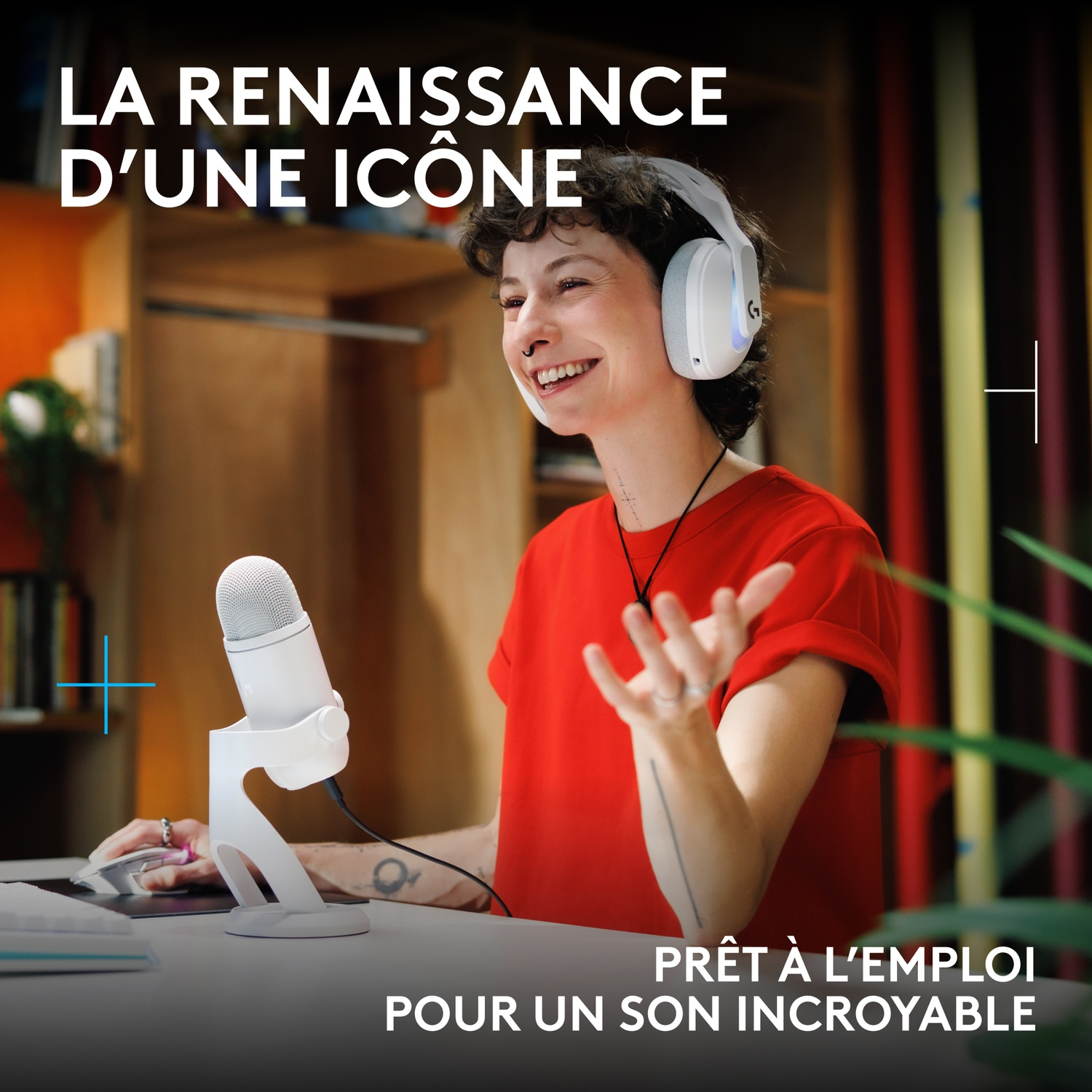 Personne en chemise rouge avec un casque blanc et un micro souriant en studio.
