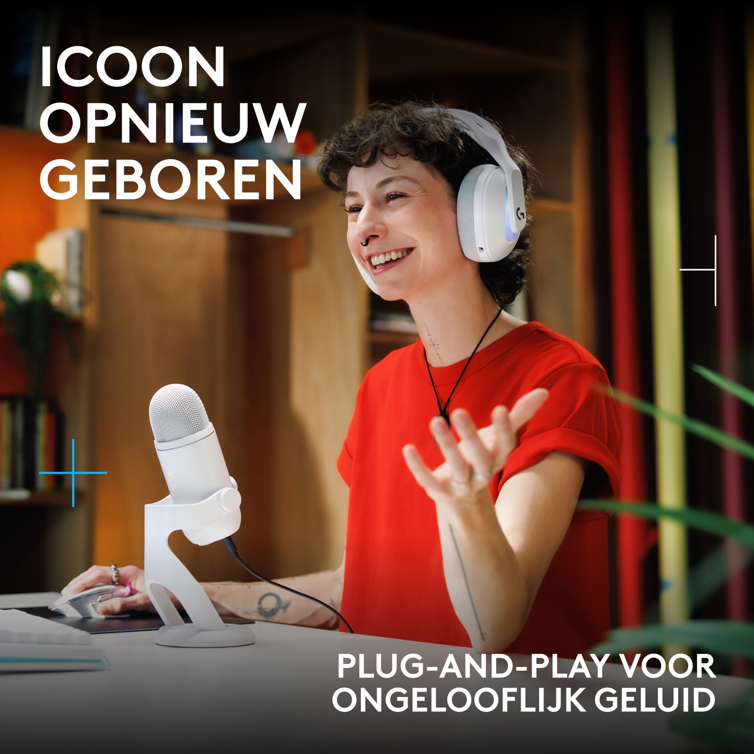Een vrouw in een rood shirt met een witte koptelefoon zit aan een bureau met een microfoon.