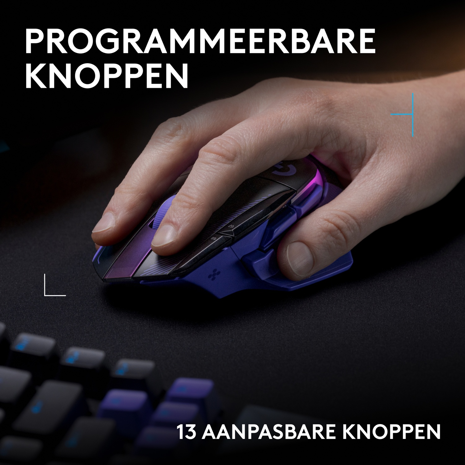 Een hand gebruikt een paarse en zwarte gamingmuis op een bureau met toetsenbord.