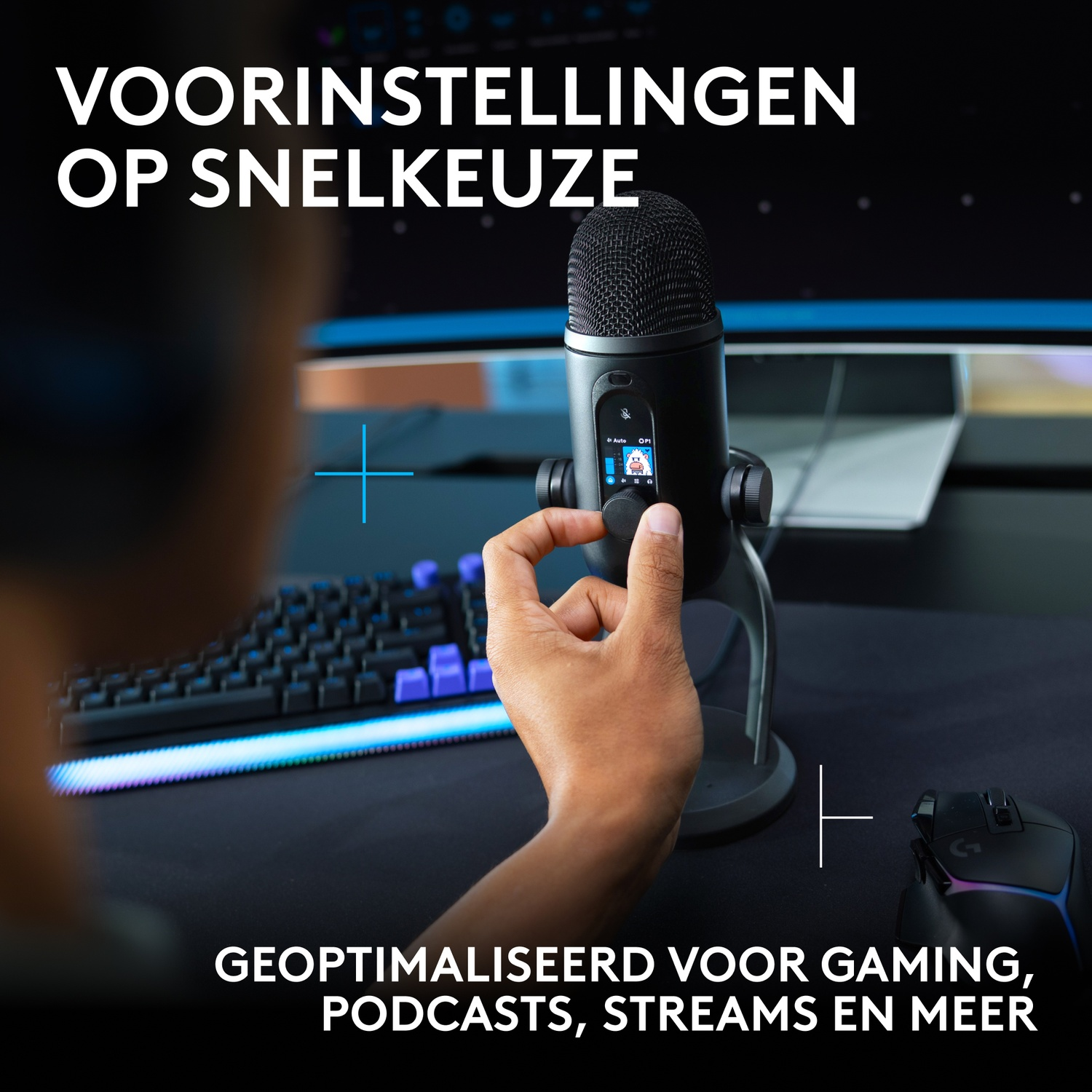 Hand past een microfoon aan, met gamingtoetsenbord en monitor op de achtergrond.