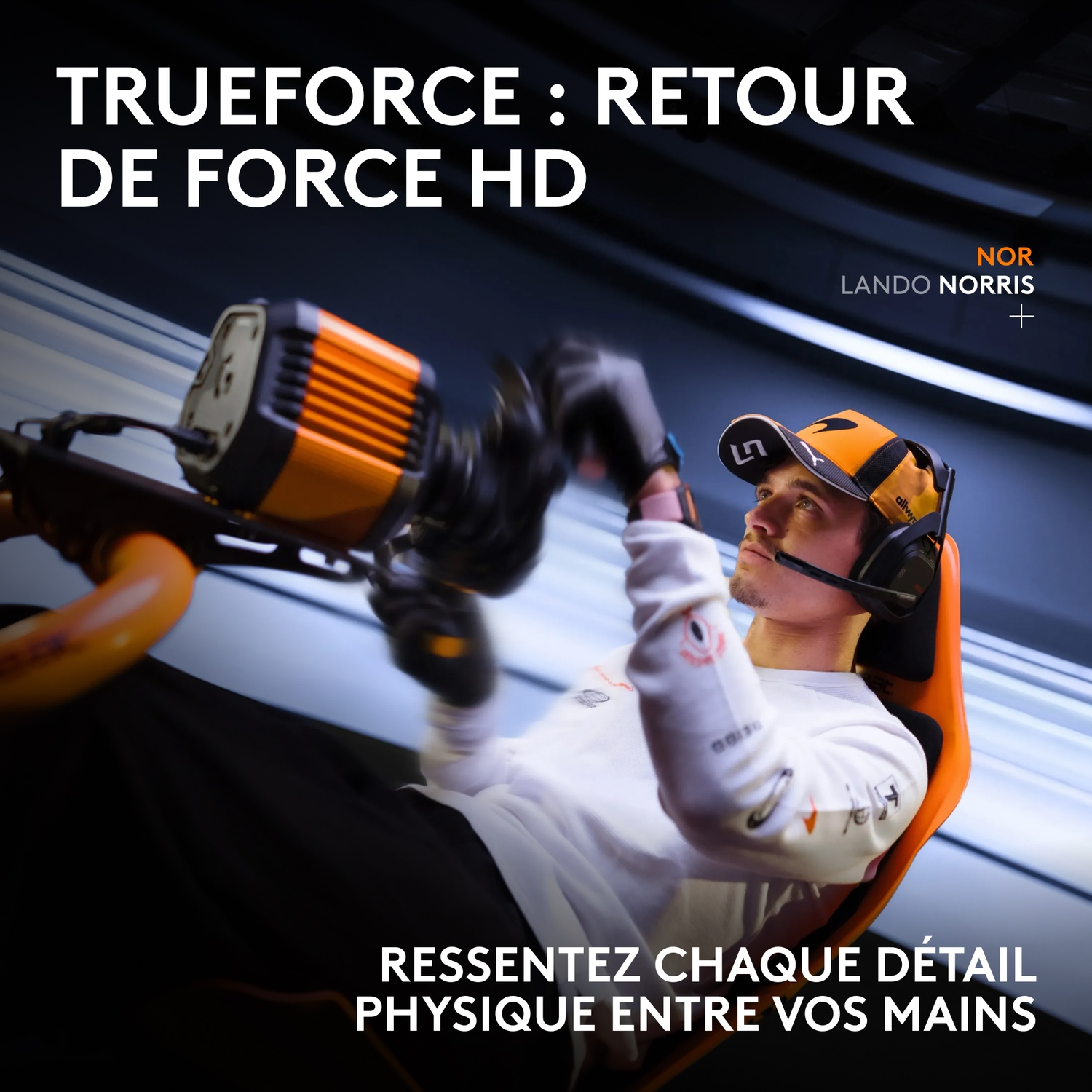 Lando Norris dans un simulateur de course tient un volant orange, avec du texte sur Trueforce.