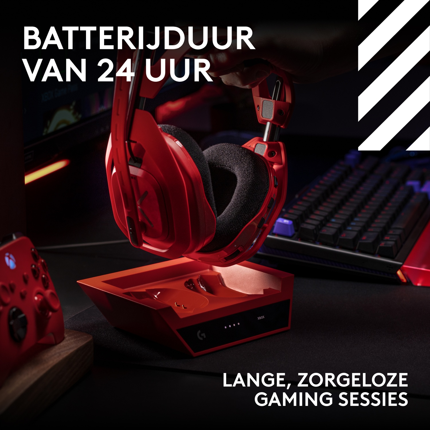 Een rode gaming-headset wordt boven een rood oplaadstation gehouden, met een toetsenbord en controller op de achtergrond.