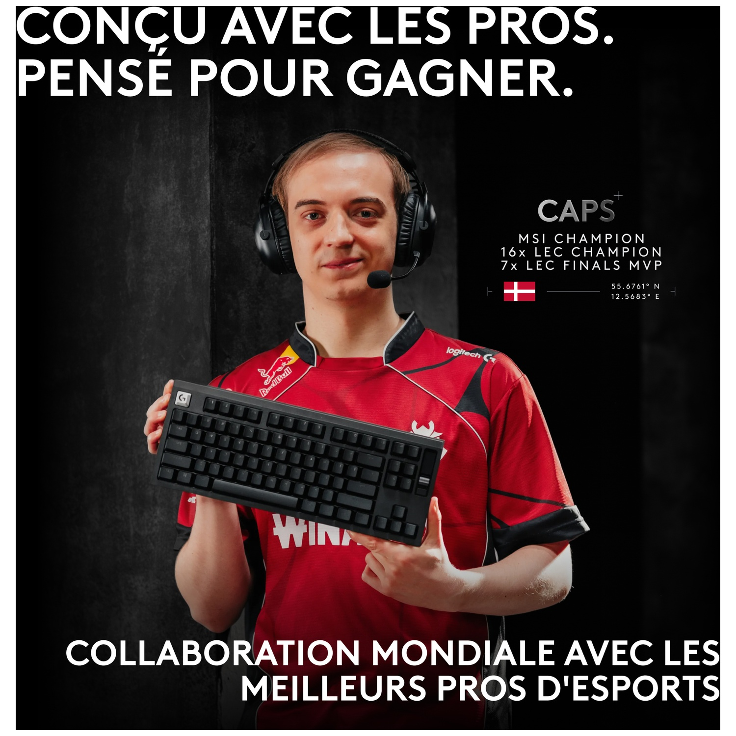 Le joueur d'eSport Caps en maillot rouge tient un clavier noir, avec texte.