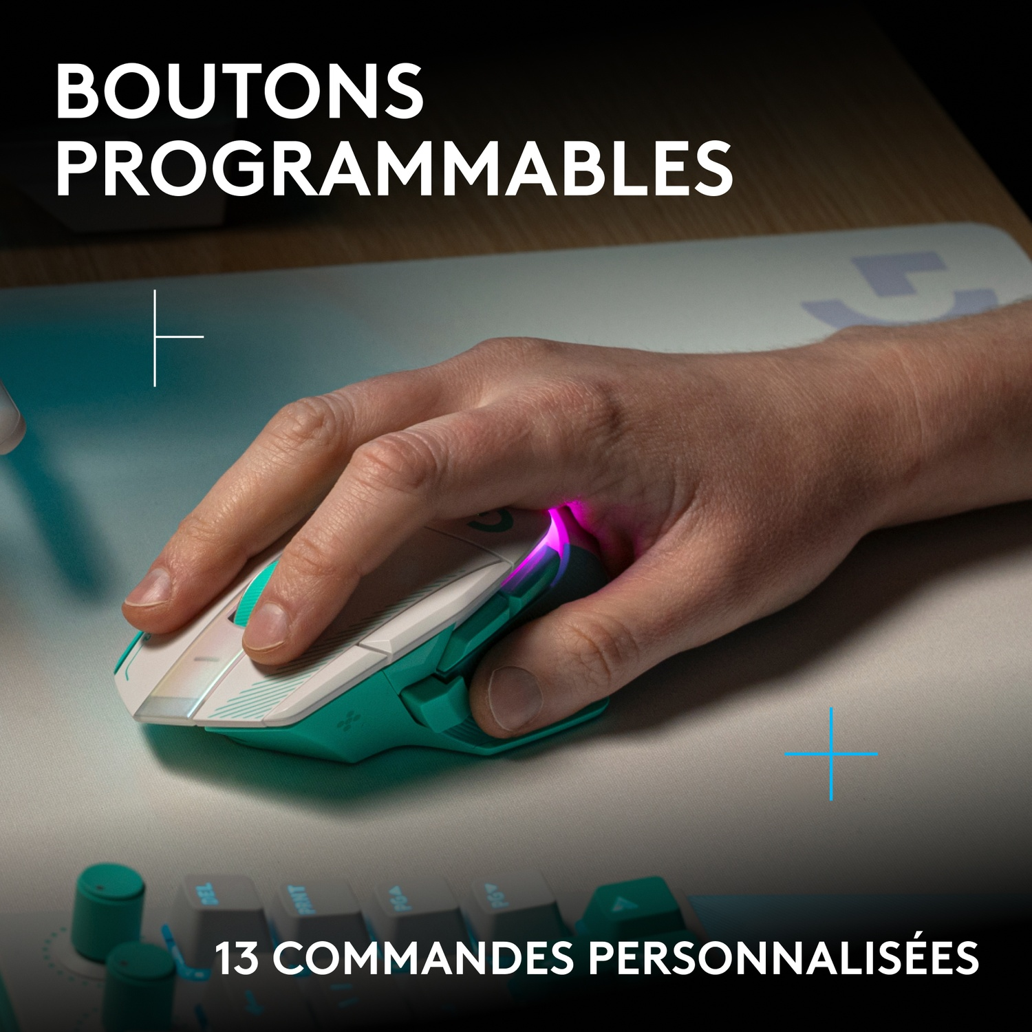 Main utilisant une souris de jeu blanche et turquoise avec éclairage LED sur un tapis.