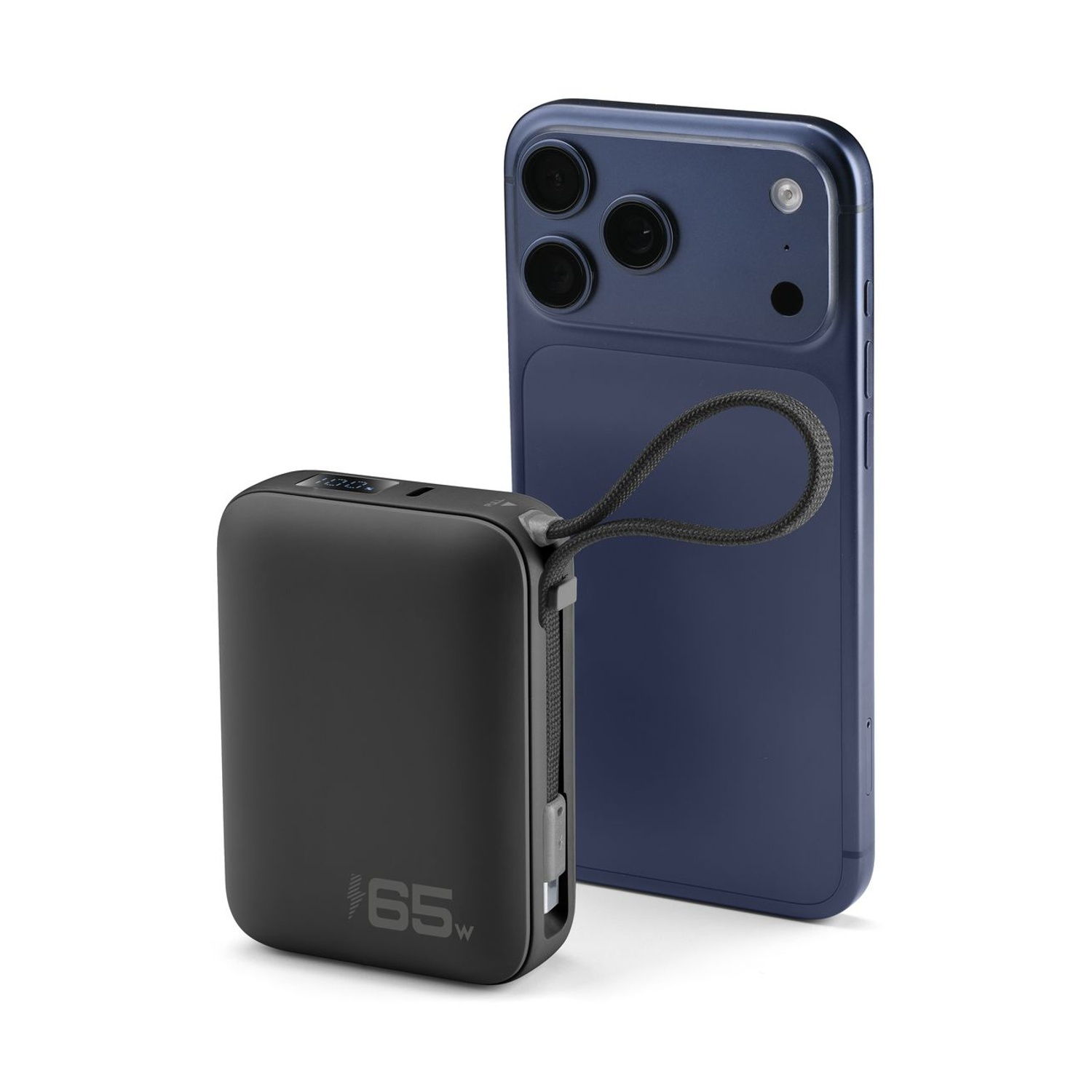 Un power bank nero da 65W accanto a uno smartphone blu su sfondo bianco.