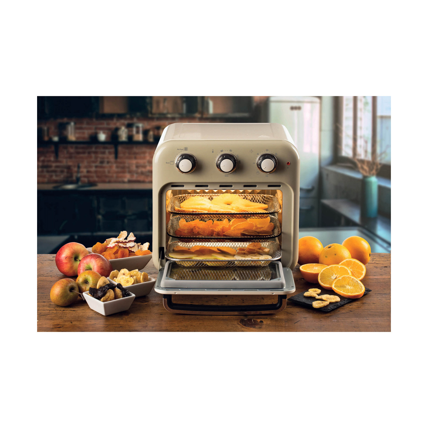 Essiccatore beige su tavolo in legno con frutta fresca, ciotole di frutta secca e arance a fette.