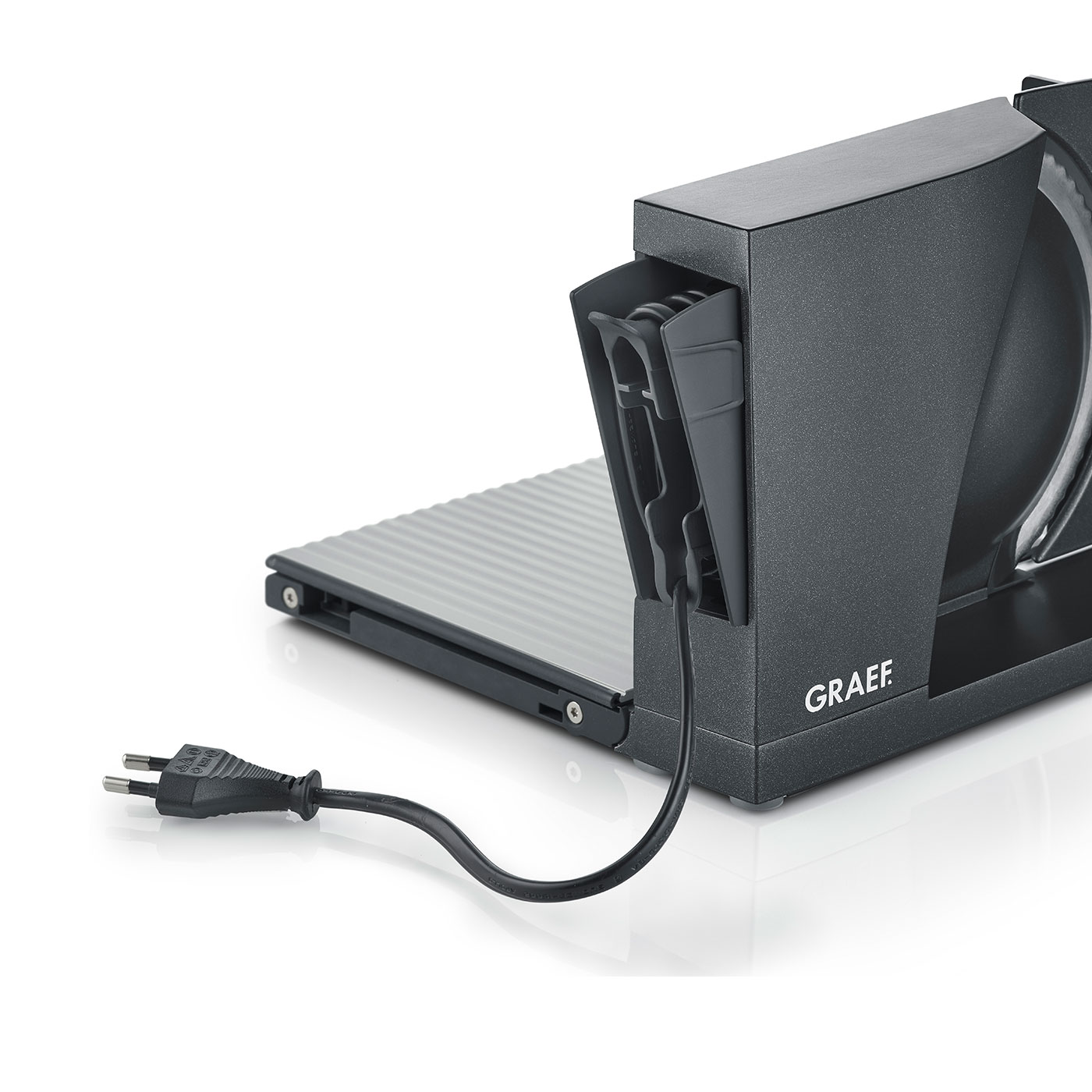 Schwarzer Graef Allesschneider mit Netzkabel und Stecker auf heller Oberfläche.