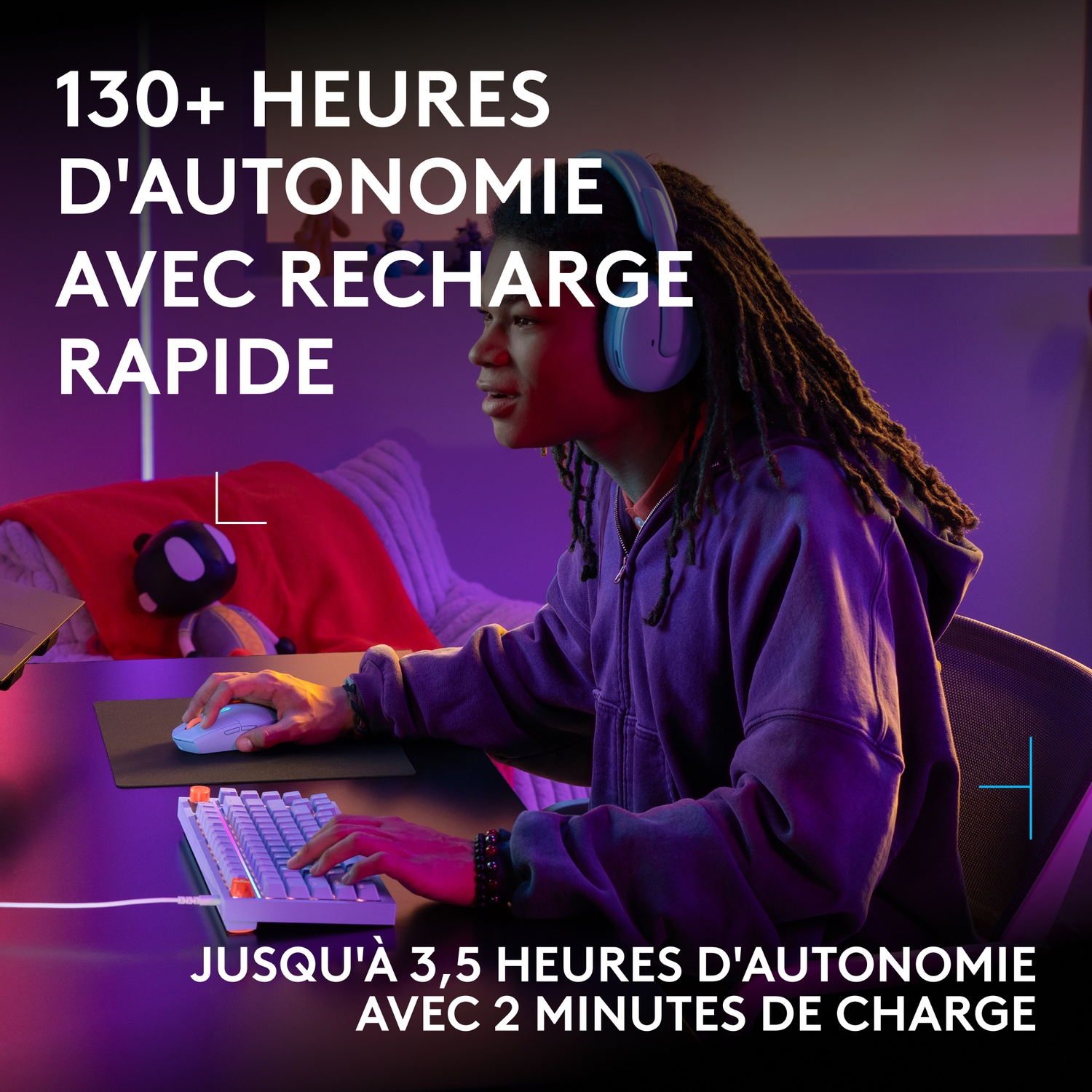 Un jeune homme avec des dreadlocks et un casque est assis à un ordinateur, jouant dans une pièce à l'éclairage violet.