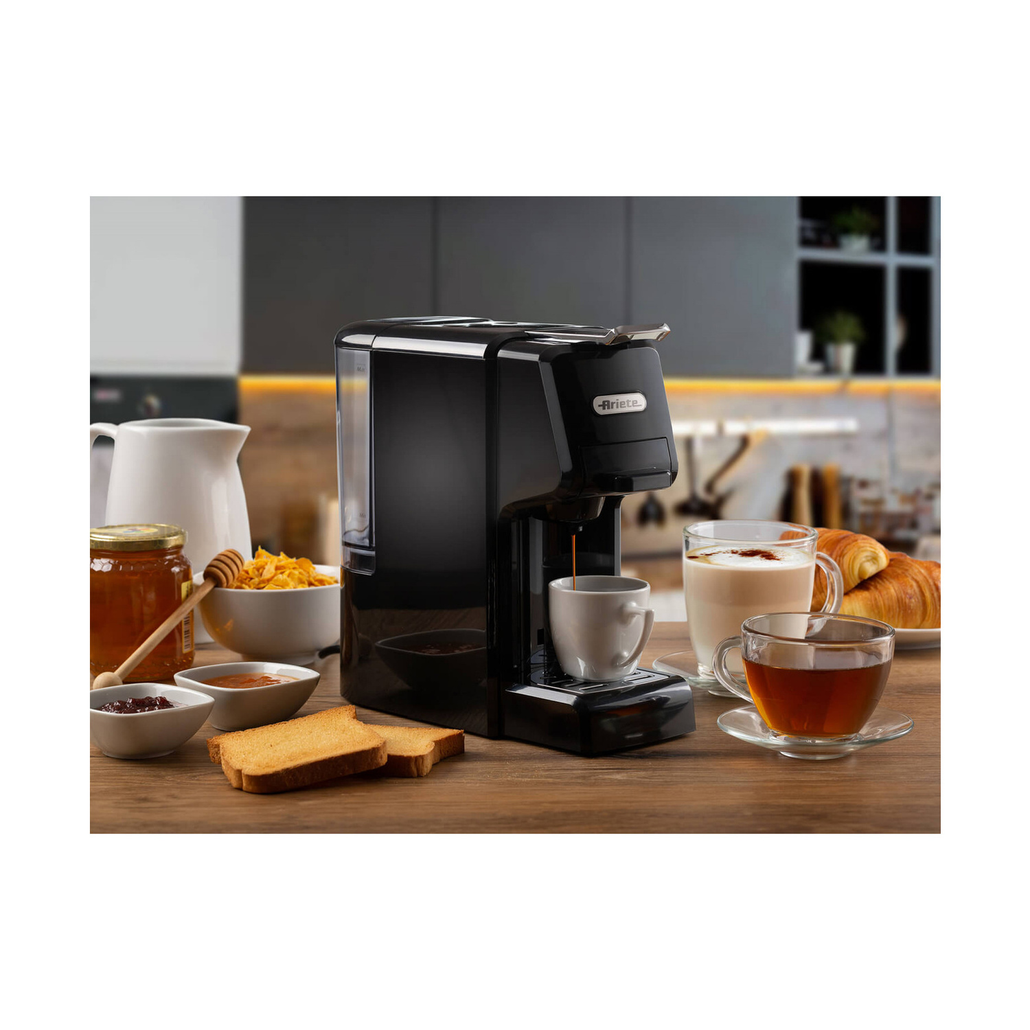 Macchina da caffè nera su tavolo di legno con tazze, pane e creme.