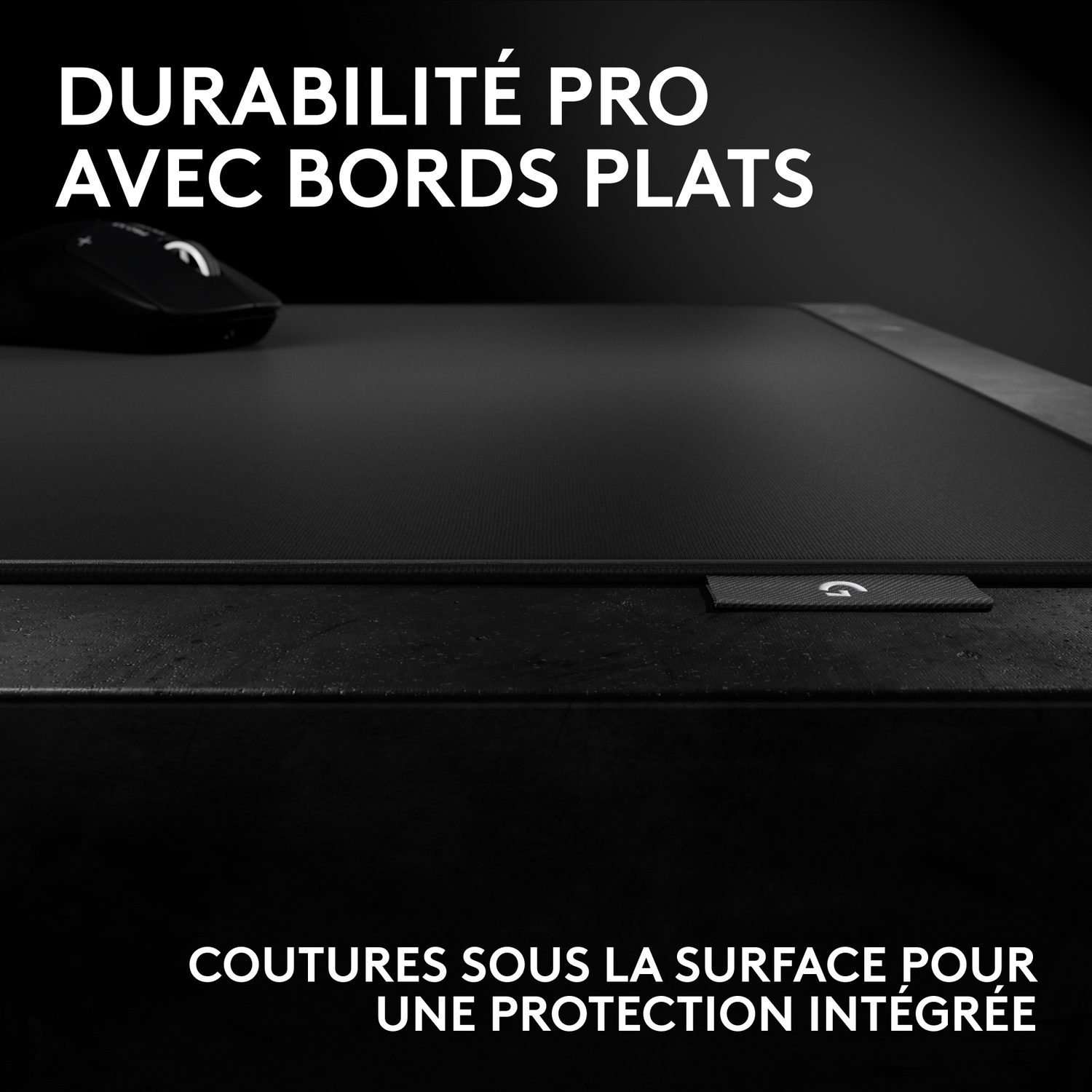 Tapis de souris noir à bords plats et coutures intégrées, avec une souris en haut à gauche.