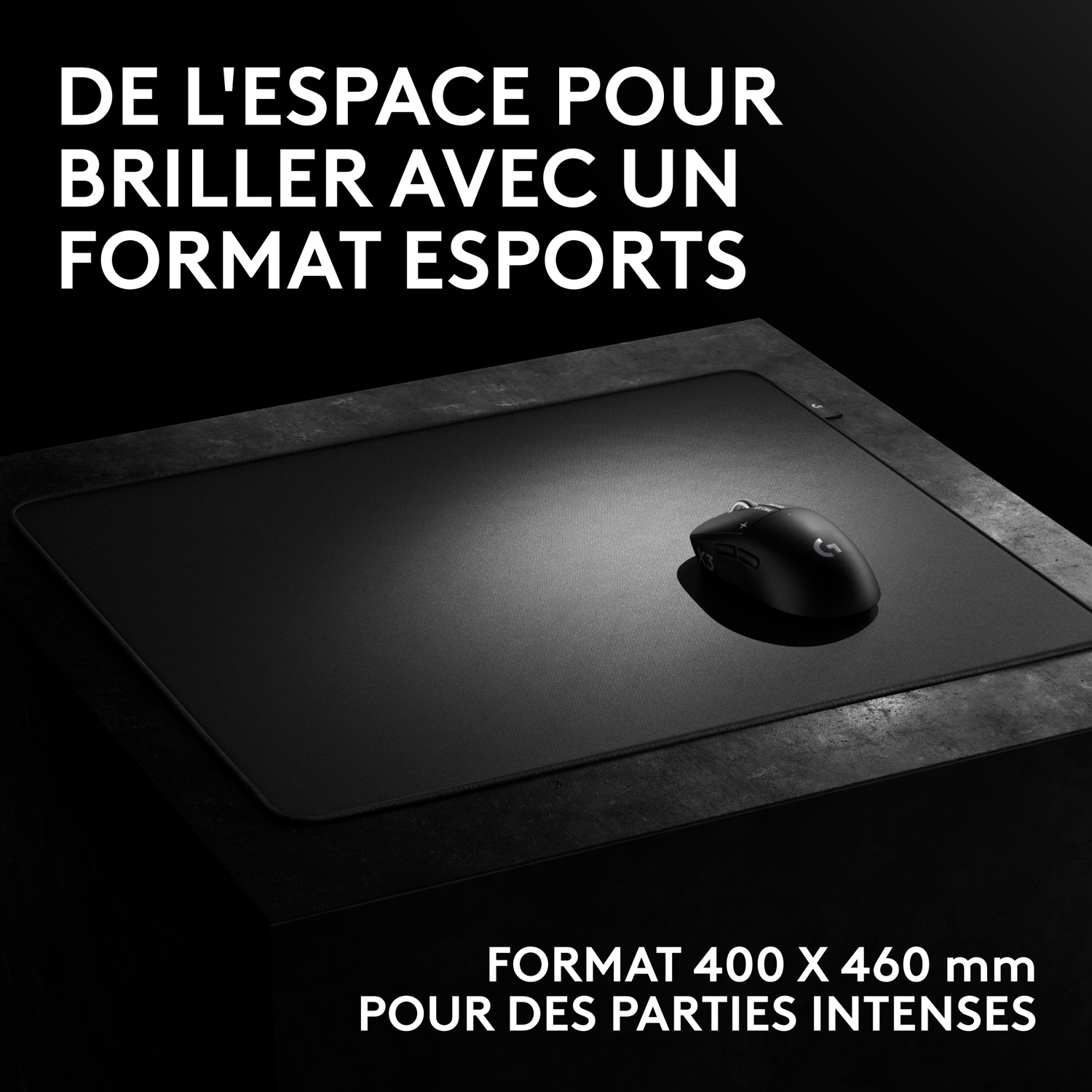 Une souris de jeu noire sur un tapis noir posé sur une surface texturée sombre, avec du texte en français.
