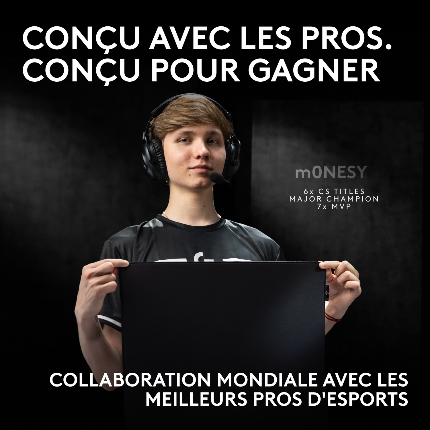 Le joueur d'esport m0NESY avec un casque tient un tapis de souris noir. Texte en surimpression.