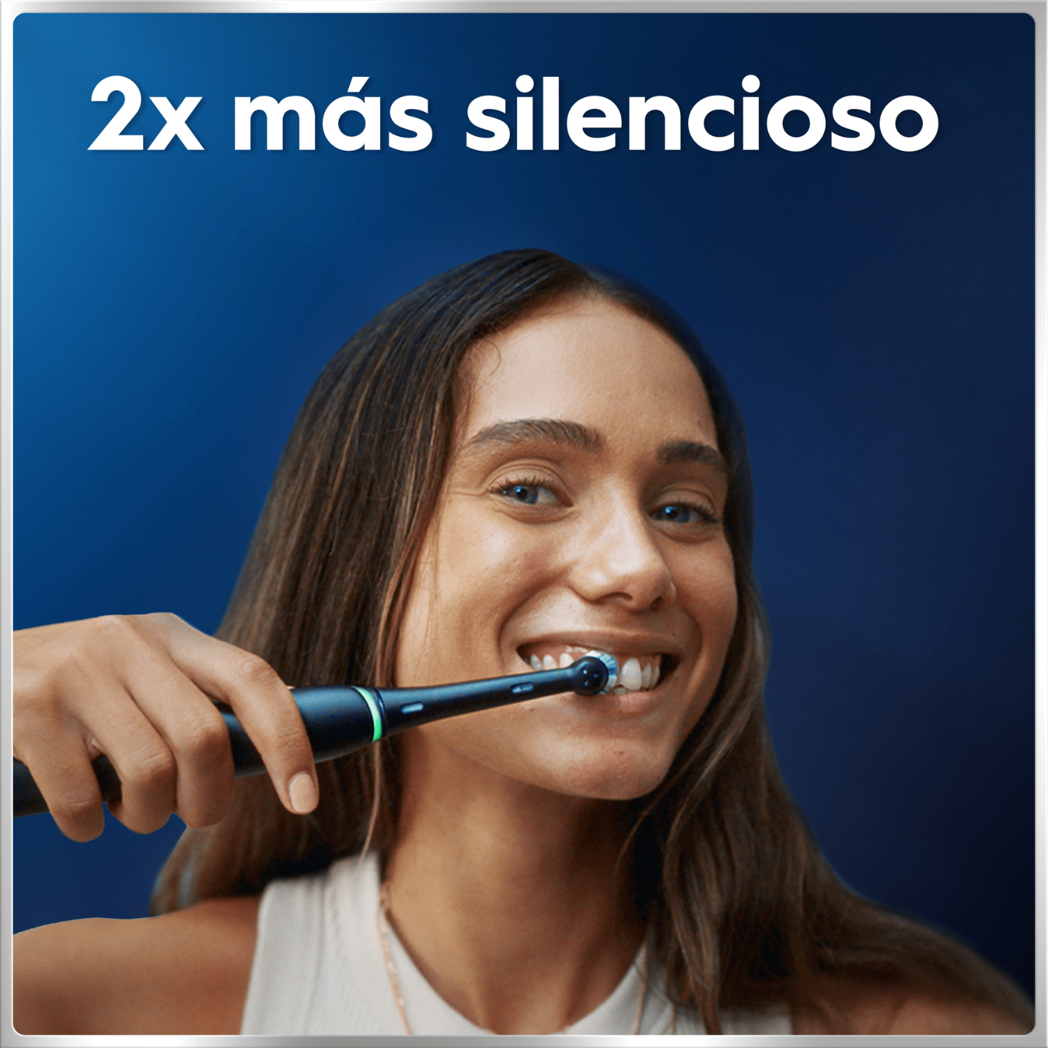 Una mujer sonriente se cepilla los dientes con un cepillo eléctrico negro sobre fondo azul.
