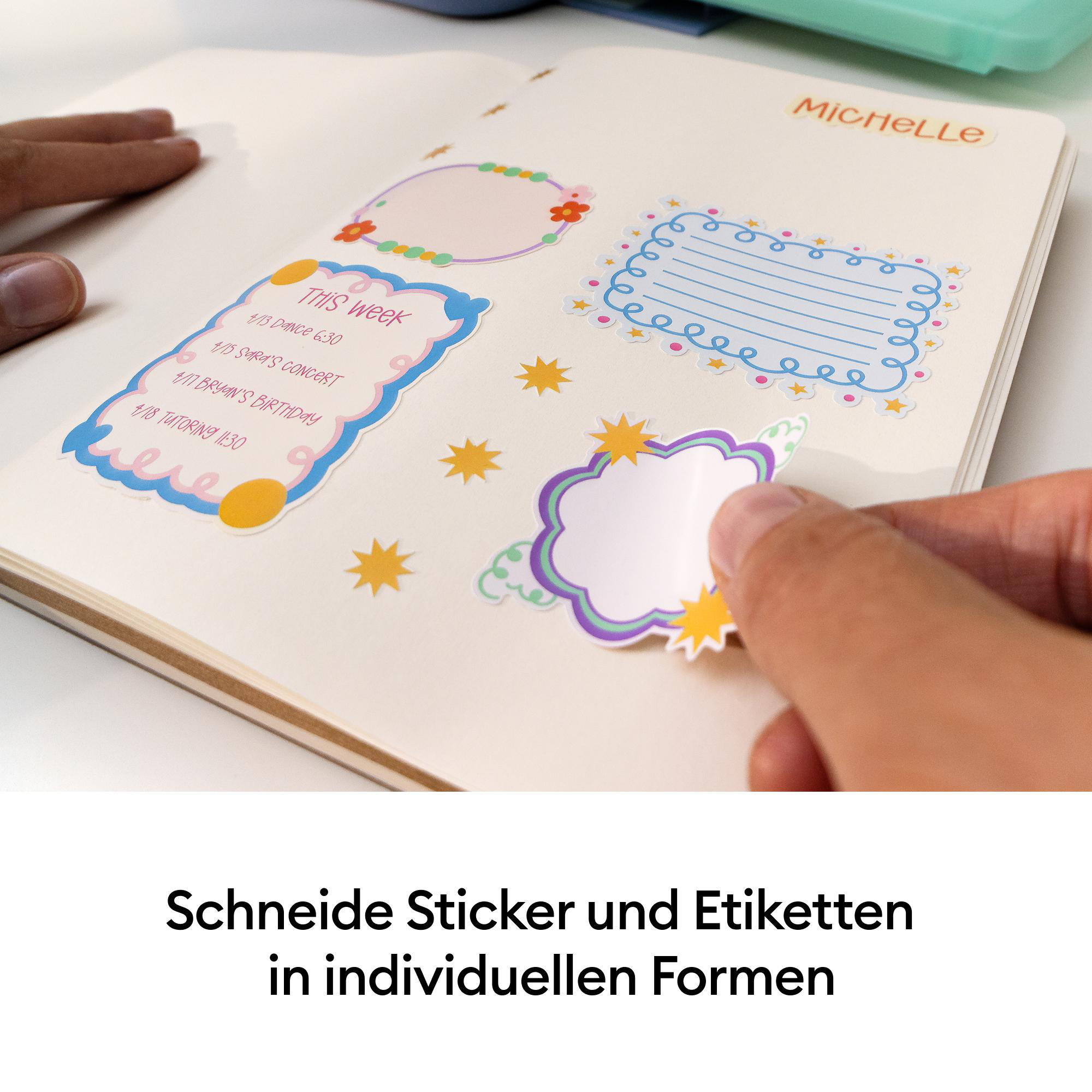 Person klebt bunte, dekorative Sticker in ein offenes Notizbuch mit dem Namen Michelle.