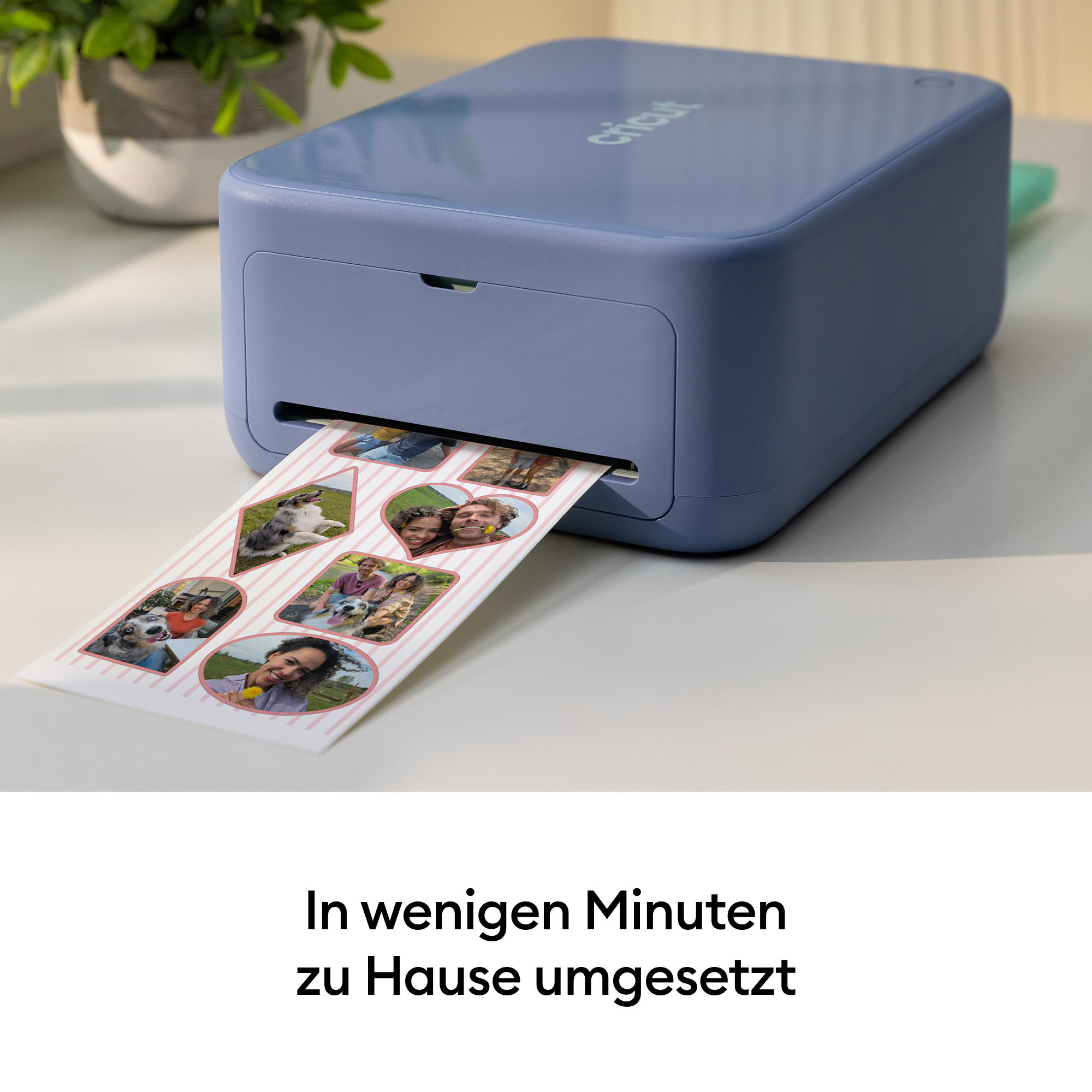 Ein blauer Fotodrucker steht auf einem Tisch und druckt ein Blatt mit mehreren kleinen Fotos aus.