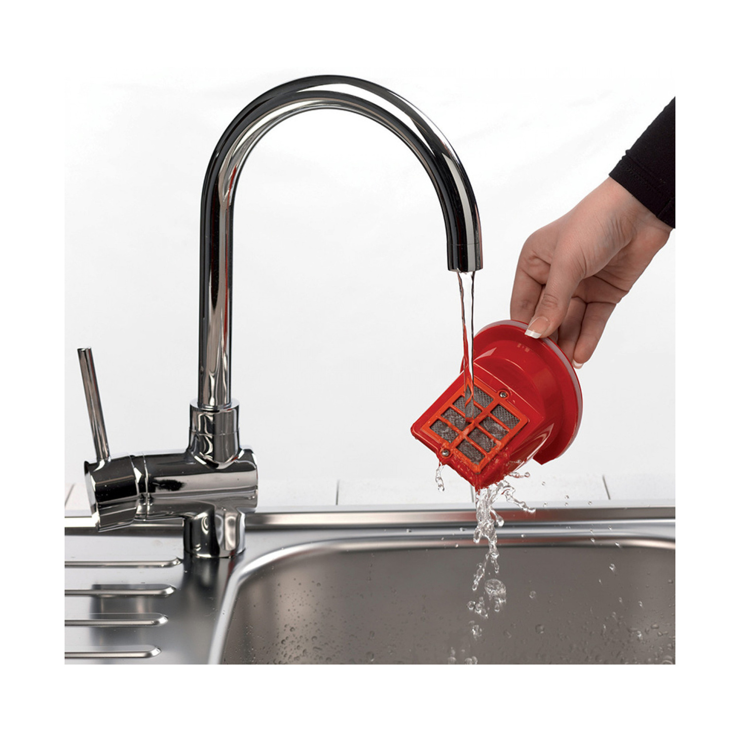 Una mano lava un filtro rosso sotto l'acqua corrente di un moderno rubinetto cromato sopra un lavello in acciaio inox.