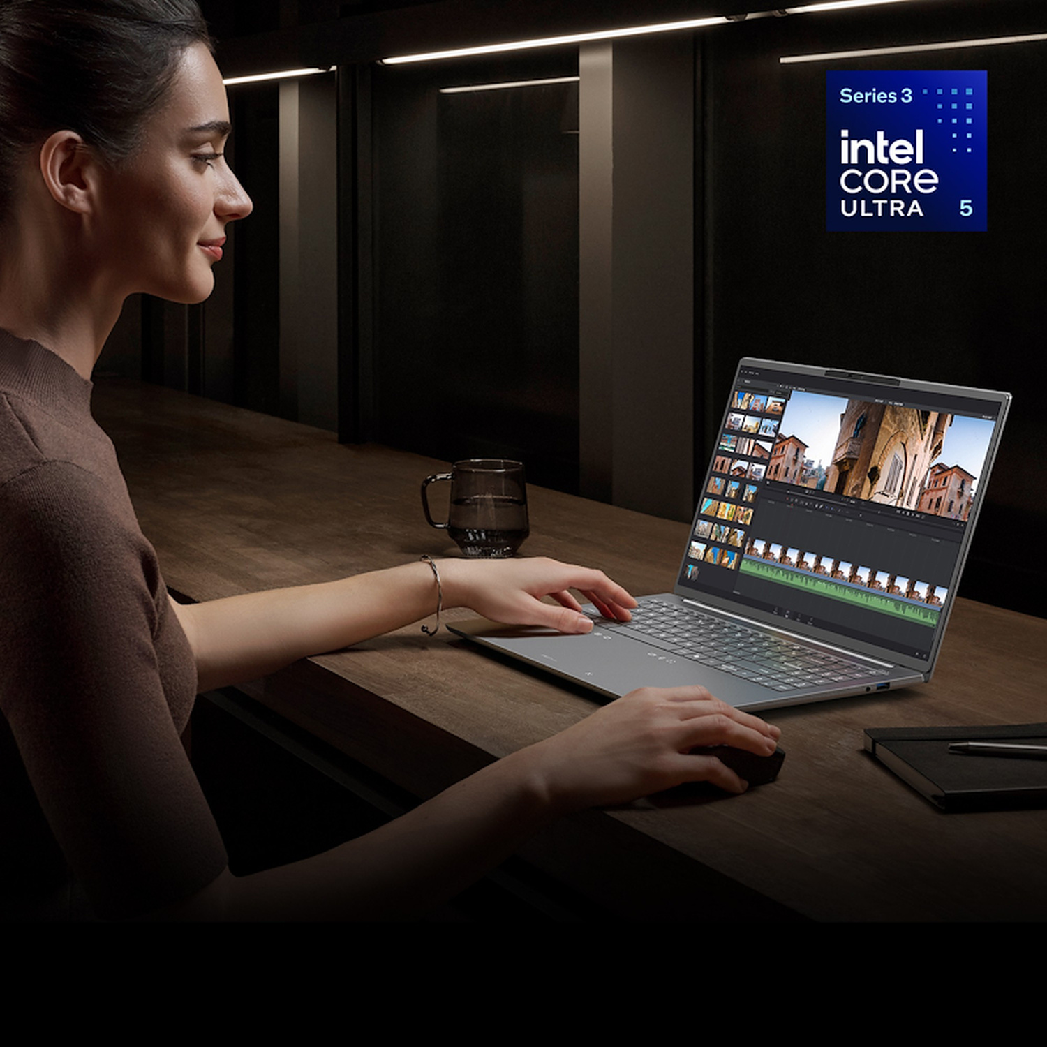 Una donna lavora su un computer portatile Intel Core Ultra 5 su una scrivania di legno.