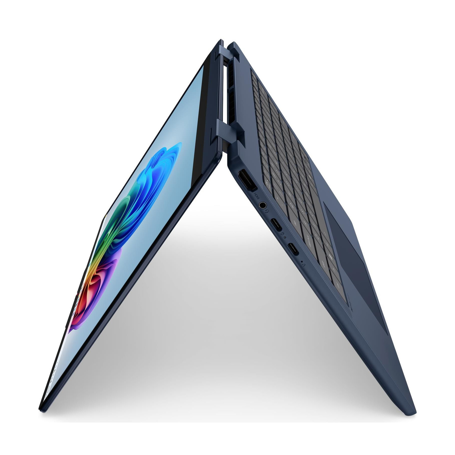 Un computer portatile blu è leggermente aperto e verticale su una superficie bianca.