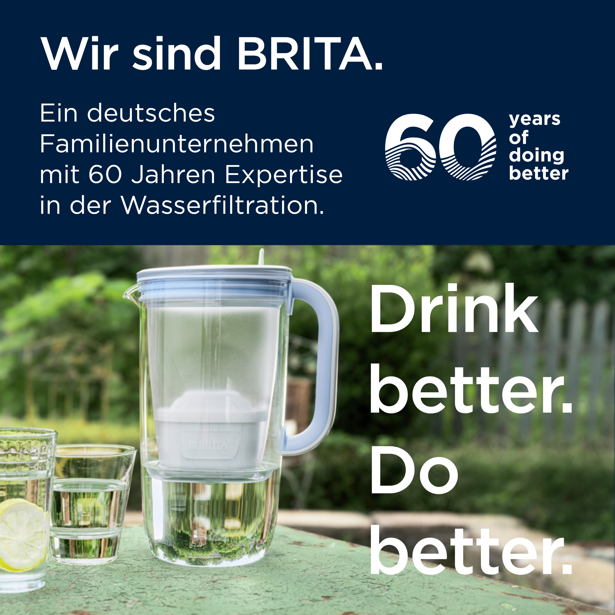 Eine Brita-Wasserfilterkanne auf einem grünen Tisch im Garten neben zwei Gläsern mit Wasser und Zitrone.
