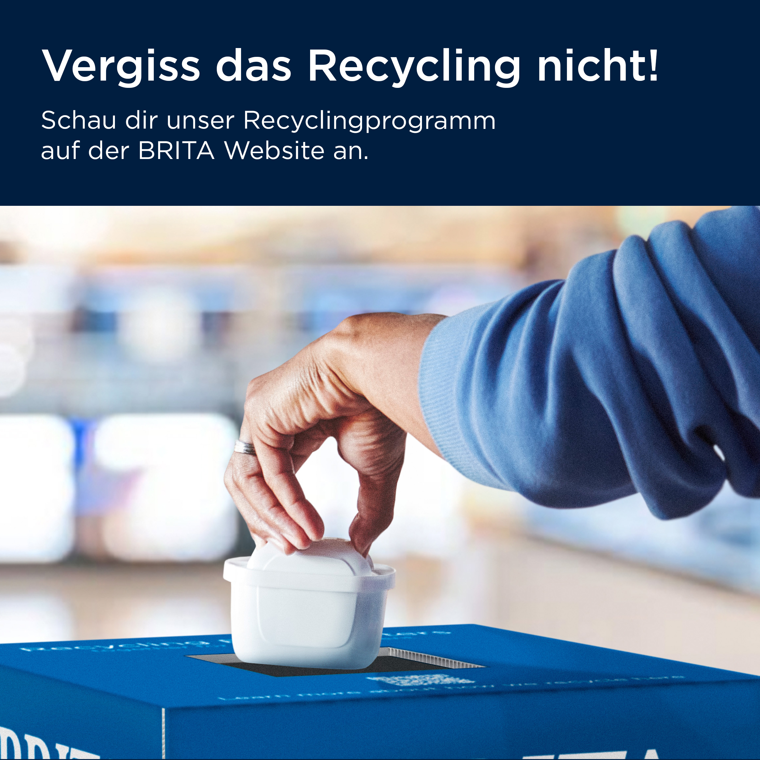 Eine Hand wirft eine weiße Filterkartusche in eine blaue Recyclingbox.