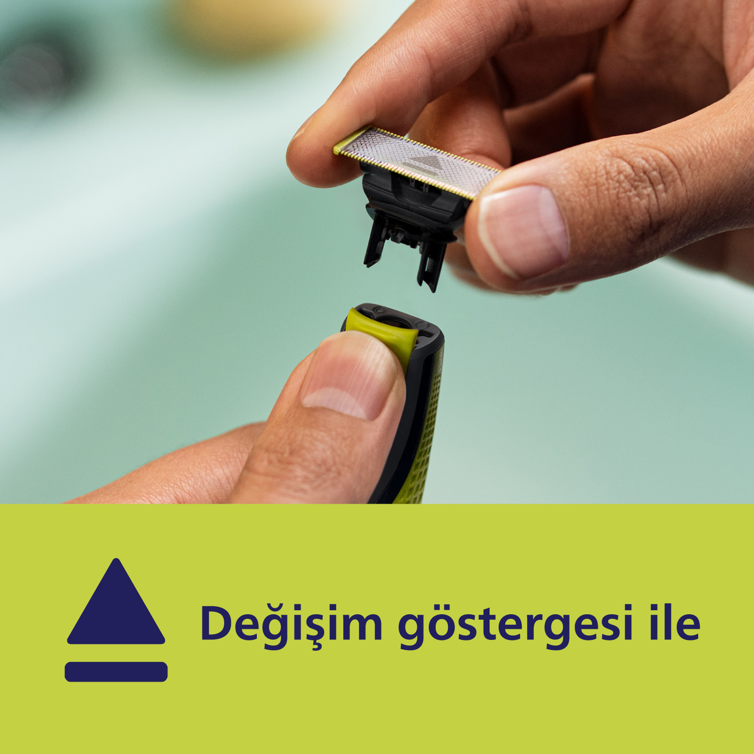 Üçgen simgeli ve altta metin bulunan yeşil tıraş makinesinin başlığını değiştiren eller.