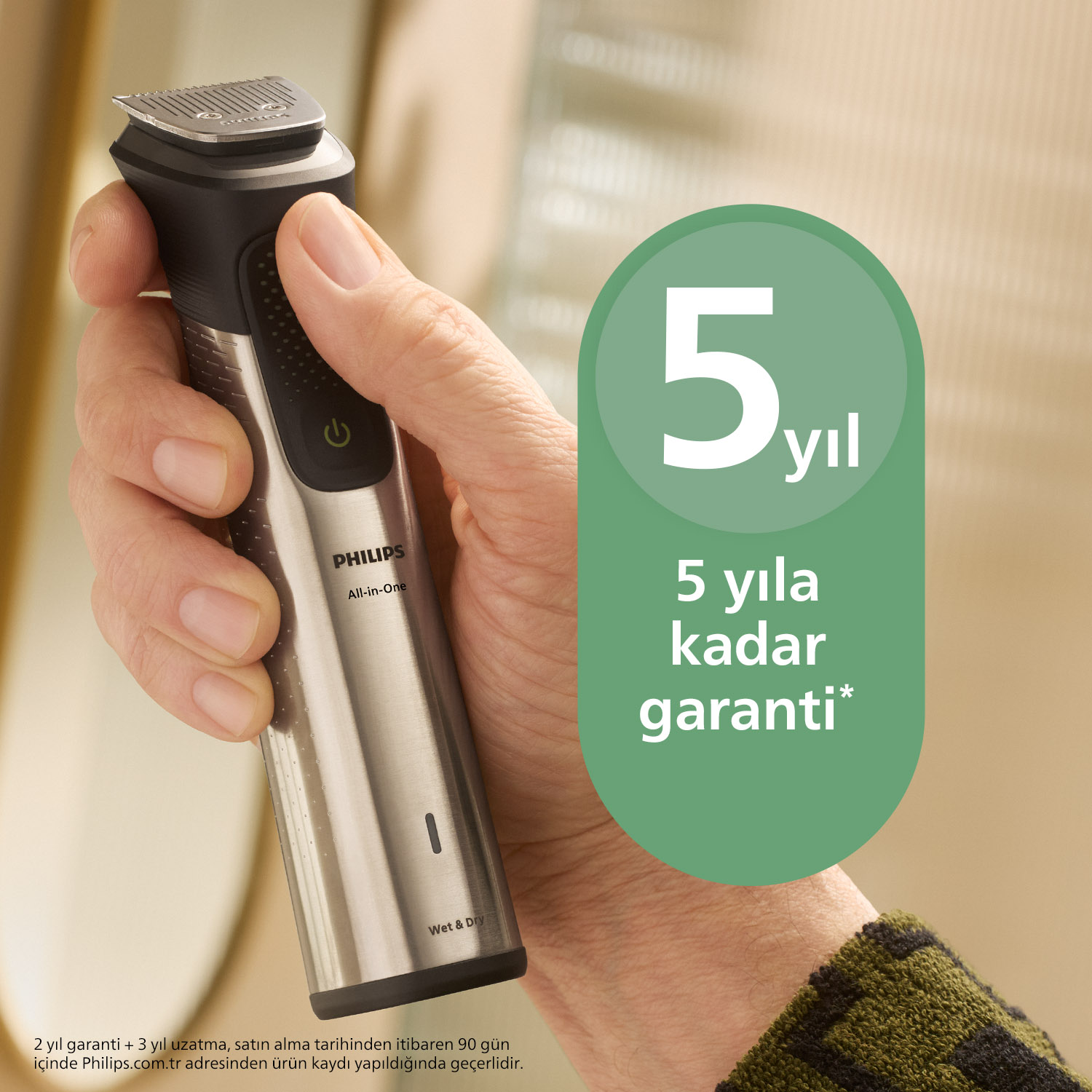 Bir el, gümüş ve siyah Philips tıraş makinesini 5 yıl garanti yazan yeşil bir tabelanın yanında tutuyor.