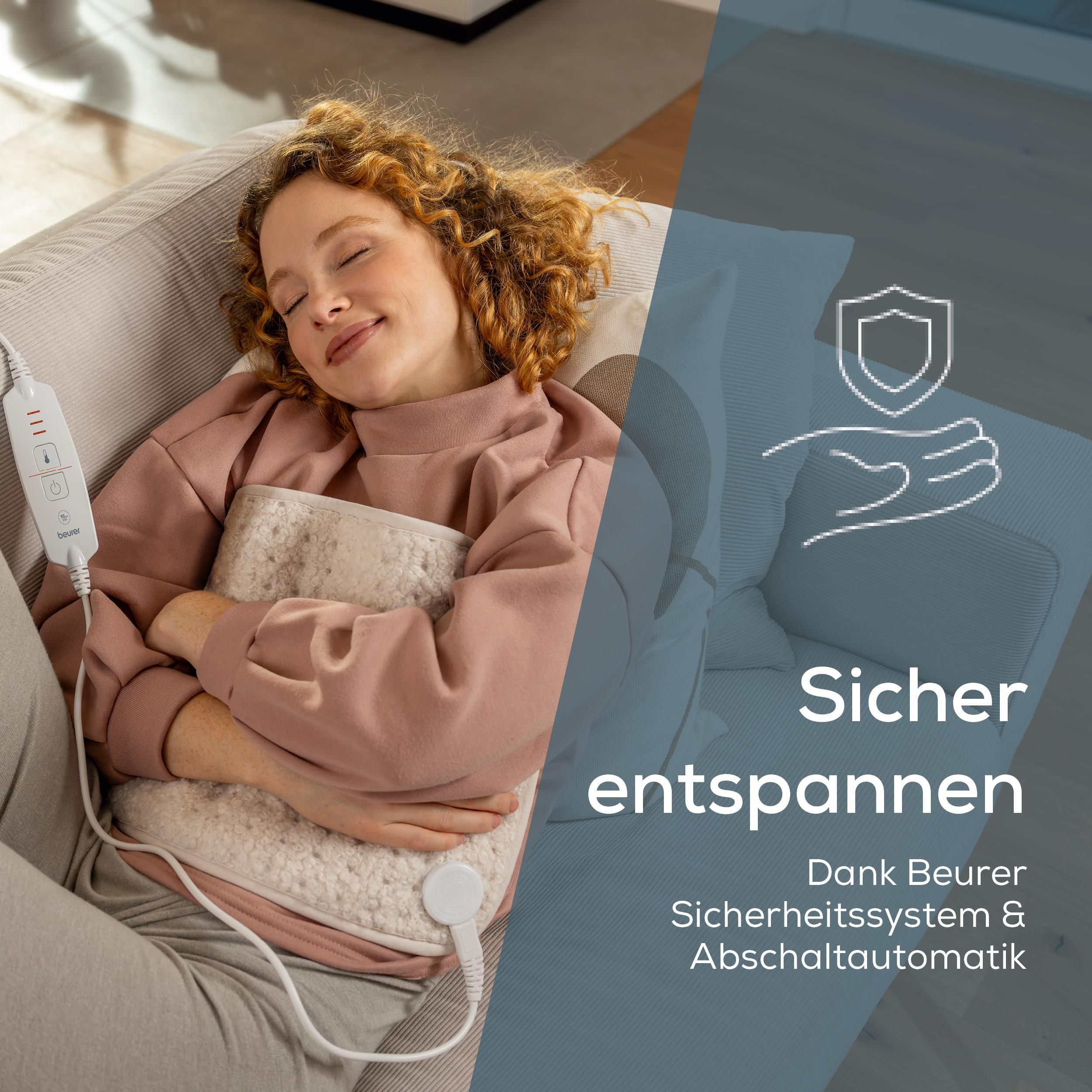 Eine Frau ruht auf einem Sofa und hält eine flauschige Heizdecke mit einem weißen Steuerungselement im Arm.