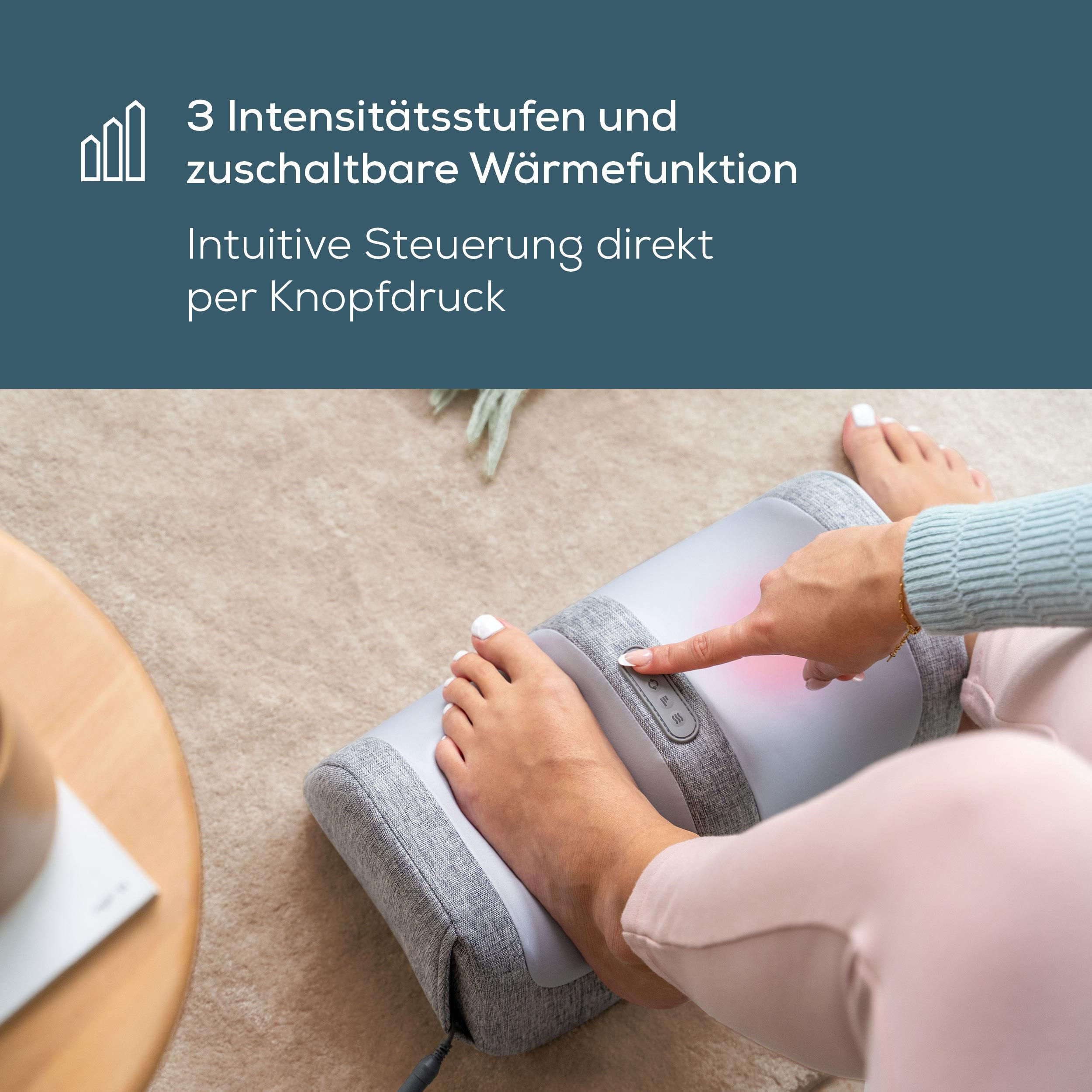 Person bedient graues Fußmassagegerät mit Wärmefunktion über Knopfdruck.