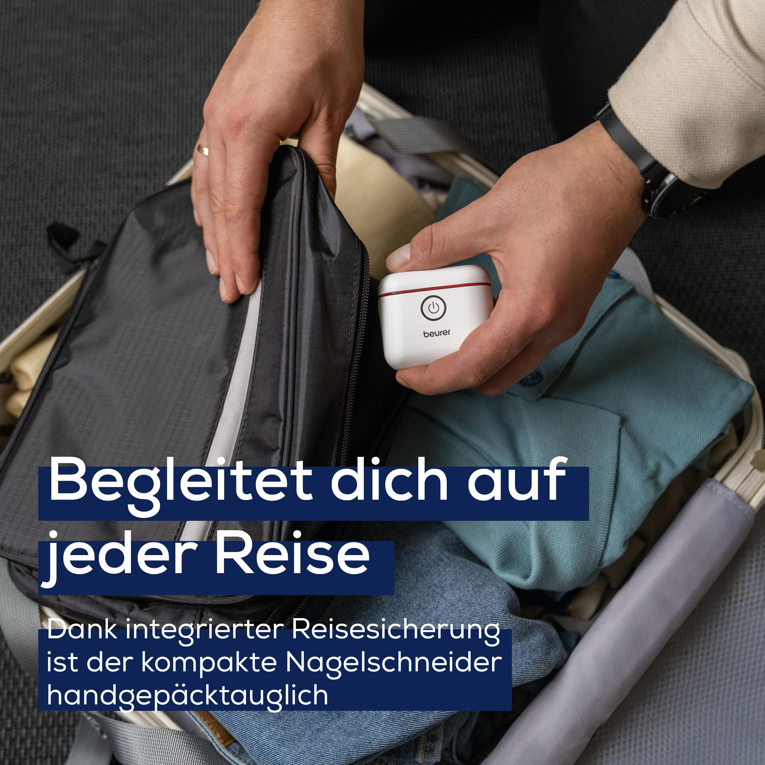 Person packt kleinen weißen Nagelschneider in einen Koffer.